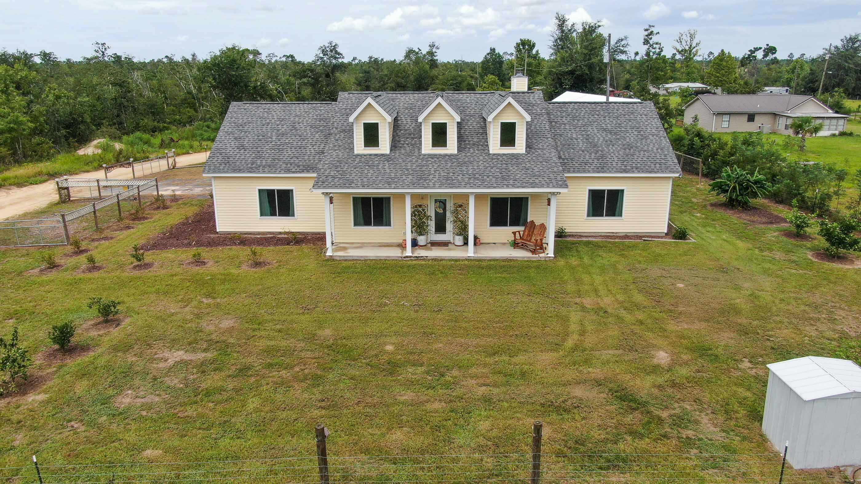Unique opportunity to own a custom built home situated on close to 5 acres w/2 pole barns. About an acre is fenced so you have options for the rest of the land. The house is solar & generator ready (no solar currently on the house), has an Iron & Sulfur separator system & hurricane impact windows. Inside you'll love the open floor plan, large foyer, real wood burning fireplace w/shelving on each side, beautiful LVP flooring, dedicated office & more! The kitchen has an abundance of cabinetry, nice pantry & large dining area with a custom built dining room table (table comes with the house). The primary bedroom has 2 walk-in closets an attached bathroom w/ double sinks, soaker tub & separate shower. Two bedrooms share an attached bathroom. You'll appreciate the gigantic laundry room.