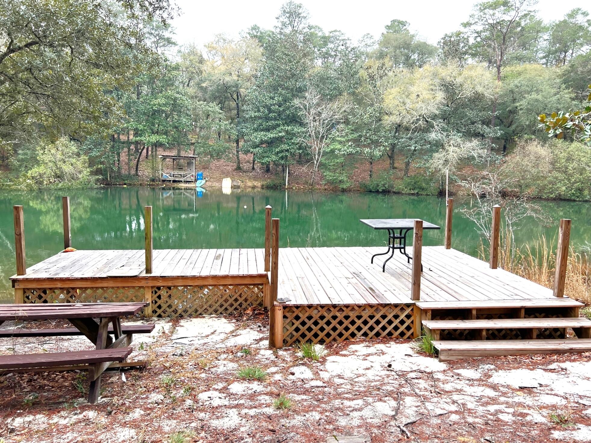 Affordable waterfront home on Leisure Lake (a private, stocked lake). Beautiful 1 acre lot with apx. 200' of waterfront and your own private dock! The 3 BR, 2 bath 2006 Fleetwood manufactured home features walk-in closets (all bedrooms); new roof in late 2020; double vanities, garden tub and separate shower in master bath; kitchen island; laundry room. Beautiful views of the lake from the covered back deck, which also features a hot tub. Seller will leave riding mower for new buyer.   This one won't last long, so schedule your showing today! There is a $100 yearly fee for maintenance of lake.