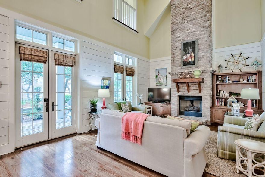 Location and lifestyle come together at this well-appointed home in WaterColor. Set on a large lot, there's ample space to add a carriage house and/or pool. The shady full-width porch is perfect for quiet relaxing and alfresco dining. Double doors lead inside. The open-plan living room is designed to make you pause and take in the tastefulsurroundings and new living room furniture included in the sale. A two-story brick fireplace and feature chimney draw the eye upwards to admire the exposed beams andlofty vaulted ceiling high above. Reaching the kitchen, there's a center island and a marble-topped half wall connecting with the spacious dining area.