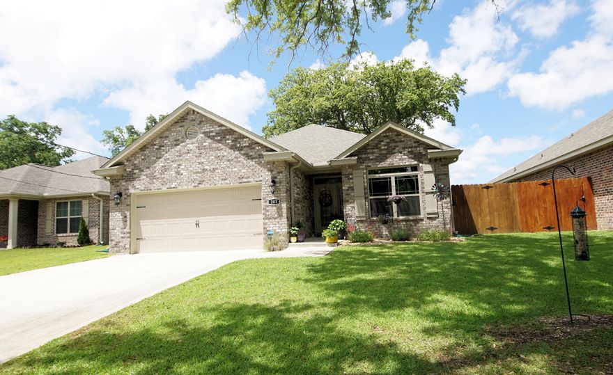 This modern home built in 2020 has 3 bedrooms, 2 bathrooms, and 1,856 square feet. Located in the Brynlee Crossing subdivision close to the beaches, dining, and restaurants. Enter this contemporary designed home through the beautiful front door with transom and side light and notice the open floor plan. The living room opens to the kitchen and dining room. The kitchen features cabinets with crown, granite countertops, white brick lay backsplash, and stainless-steel appliances. The appliances include a slide in stainless and black stove, built-in microwave, dishwasher, and a French door refrigerator with an icemaker. There are pendant and recessed lighting in the kitchen as well as a breakfast bar that seats two to three. The dining area has a chandelier and a glass door with transom