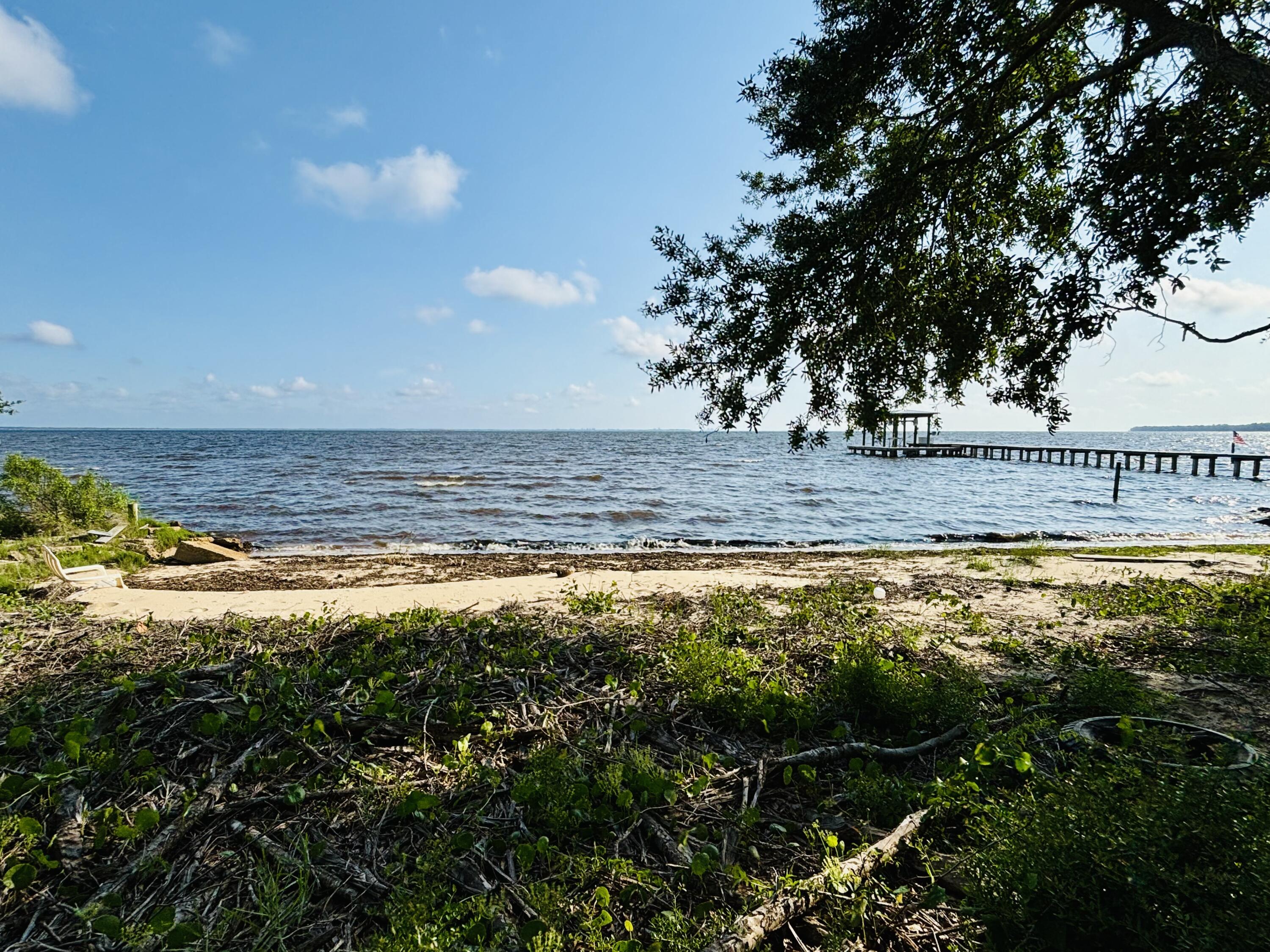 Step into a realm of unparalleled tranquility and discover a truly rare opportunity to own a slice of bayfront paradise. This exceptional .76-acre residential parcel overlooking Choctawhatchee Bay is more than just land; it is a canvas for your most exquisite waterfront dreams.As the day unfolds, find sanctuary under the canopy of majestic oak and cypress trees and admire their timeless beauty, offering a serene escape from the everyday.The true magic unfolds as the sun begins its descent. Prepare to be captivated by breathtaking sunsets that paint the sky in a kaleidoscope of vibrant hues, enjoyed from the privacy of your own shoreline. This is not just a view; it's an experience that nourishes the soul.This extraordinary property also offers the capability of building your own private dock. Envision setting sail from your doorstep, exploring the shimmering waters of the bay, and returning to the tranquility of your own haven. The possibilities for water-based adventures are endless.
In a world where true waterfront serenity is increasingly elusive, this rare .76-acre parcel stands as a testament to the beauty and potential of bayfront living. Don't miss this exciting chance to create your legacy in a location that embodies luxury, privacy, and the captivating allure of the bay. It provides the perfect blend of peace, privacy, and convenience. Nestled just minutes from the beaches of South Walton and the vibrant restaurants and shops of iconic Scenic Hwy 30A. Inquire today and begin building your serene bayfront masterpiece.
(Lot has been partially cleared)