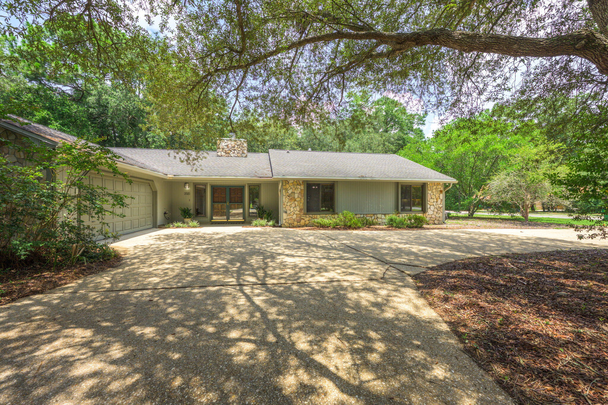 *Presented with staging furniture* A separate 3 car garage with electricity, water and its own entrance from Rocky Shores Drive because the home is on a large corner lot! This makes this home a 5 car garage residence at 2515 Edgewater Dr., Niceville. Location is key being centrally located between Niceville and Bluewater Bay. Shopping and dining options are abundant as well as proximity to Eglin AFB, Niceville High School and Northwest Florida State College. Beach access couldn't be easier at only 5 miles away using the Mid Bay bridge into Destin, which adds a plethora of activities and excursions for the whole family to enjoy. Inside you'll find a well-maintained custom home on a large, private lot backing to greenbelt in a quiet, established neighborhood with sidewalks and mature tree. This home features zoned HVAC with two separate systems, solid Oak wood and tile flooring, and vaulted wood-slat ceilings in the living room. A stone fireplace adds warmth and character, while large windows with custom wood shutters provide natural light throughout. The spacious kitchen offers extensive prep space, plenty of cabinets with drawer-style lowers and corner turntables, an instant hot water tap, and a triple-bowl sink. The primary suite includes a vaulted ceiling, two large closets, and a bathroom with a garden tub, separate shower, and a booster water heater for endless hot water. All bedrooms are generously sized; Bedroom 2 includes custom built-ins, recessed lighting, and a 12.5' desk. Additional features include built-in central vacuum, ample storage with multiple closets and attic space, and a private backyard with natural landscaping and minimal upkeep. The property includes a 2-car attached garage plus an oversized 3-car detached garage/workshop with its own gated driveway. Don't miss out and schedule your private showing today!