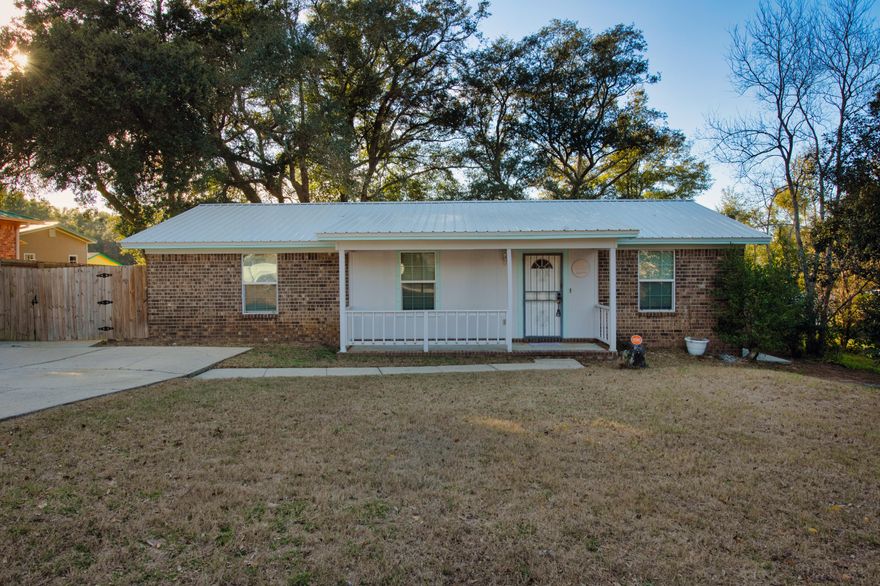 Welcome to this charming property! Step onto the covered front sitting porch and feel the warmth of this home.  With a detached single garage in the rear, you'll have plenty of space for parking and storage.  The 2020 metal roof adds a modern touch and provides durability for years to come.  Inside, with new fresh paint, you'll find stainless steel appliances in the kitchen with a brand new Frigidaire stove installed in 2024, giving it a sleek and contemporary feel. Tile throughout the home for easy maintenance with an inside laundry room for convenience and functionality. Stay connected with the electric Wifi smart water heater allows you to control and monitor your water usage.