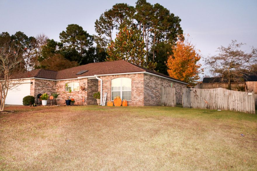 This beautiful brick home has 3 bedrooms PLUS an office/bonus/flex room and 2 bathrooms situated in a split floor plan.Open living area off of the kitchen has vaulted ceilings and skylight giving that spacious and airy feel. Sliding glass doors lead to a concrete patio and custom built-in fire pit perfect for entertaining. Retreat to a  large master bedroom and bath with double walk-in closets. Irrigation throughout the entire property. Equipped with alarm system for your families peace of mind.This perfectly located home not only has breathtaking views of the evening sunsets, it is only minutes away from nearby military bases and Hwy I-10. Roof and HVAC only 2 years old and recently serviced Septic. Sellers are ready to make this a quick close! *measurements to be verified by buyer