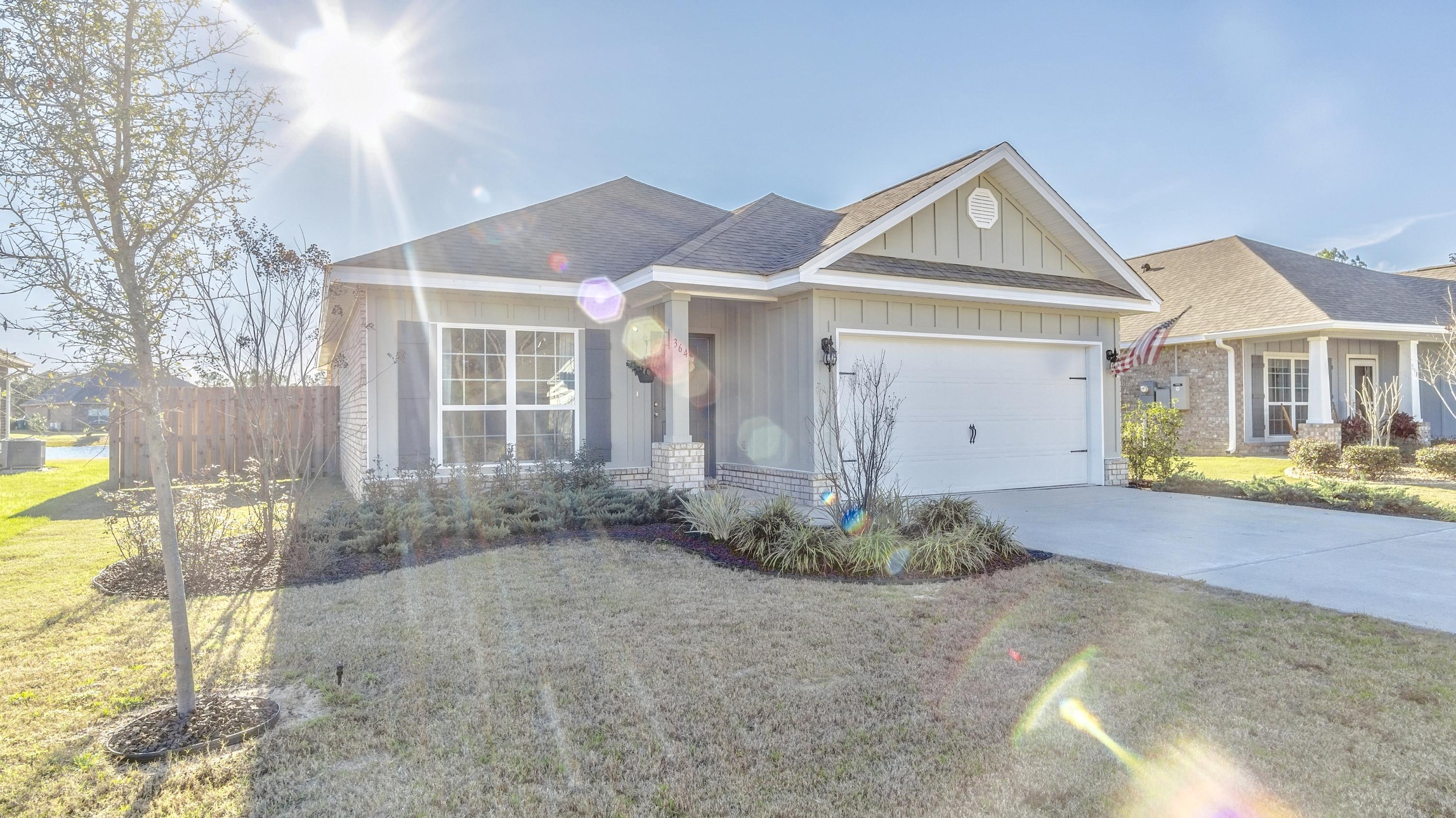 Welcome home to this beautiful waterfront Oakley floor plan inside Passages of Hammock Bay. This immaculate 3 bedroom, 2 bath home needs to be on your MUST SEE list. With new hardwood tile floors, shiplap accent walls in the guest bedroom, office with glass french doors, beautiful granite counter tops in the kitchen, storage shelves installed in the garage, lots of floored space in the attic, completely fenced in back yard overlooking the neighborhood pond, and rubber mulch gardens outside. Enjoy sensational waterfront sunsets from your back porch, master bedroom, or living room. Located in the prestigious area of Hammock Bay, a 3,000-acre bay front master-planned residential community nestled in the quiet surroundings of Freeport, Florida. Hammock Bay has all the first-class amenities