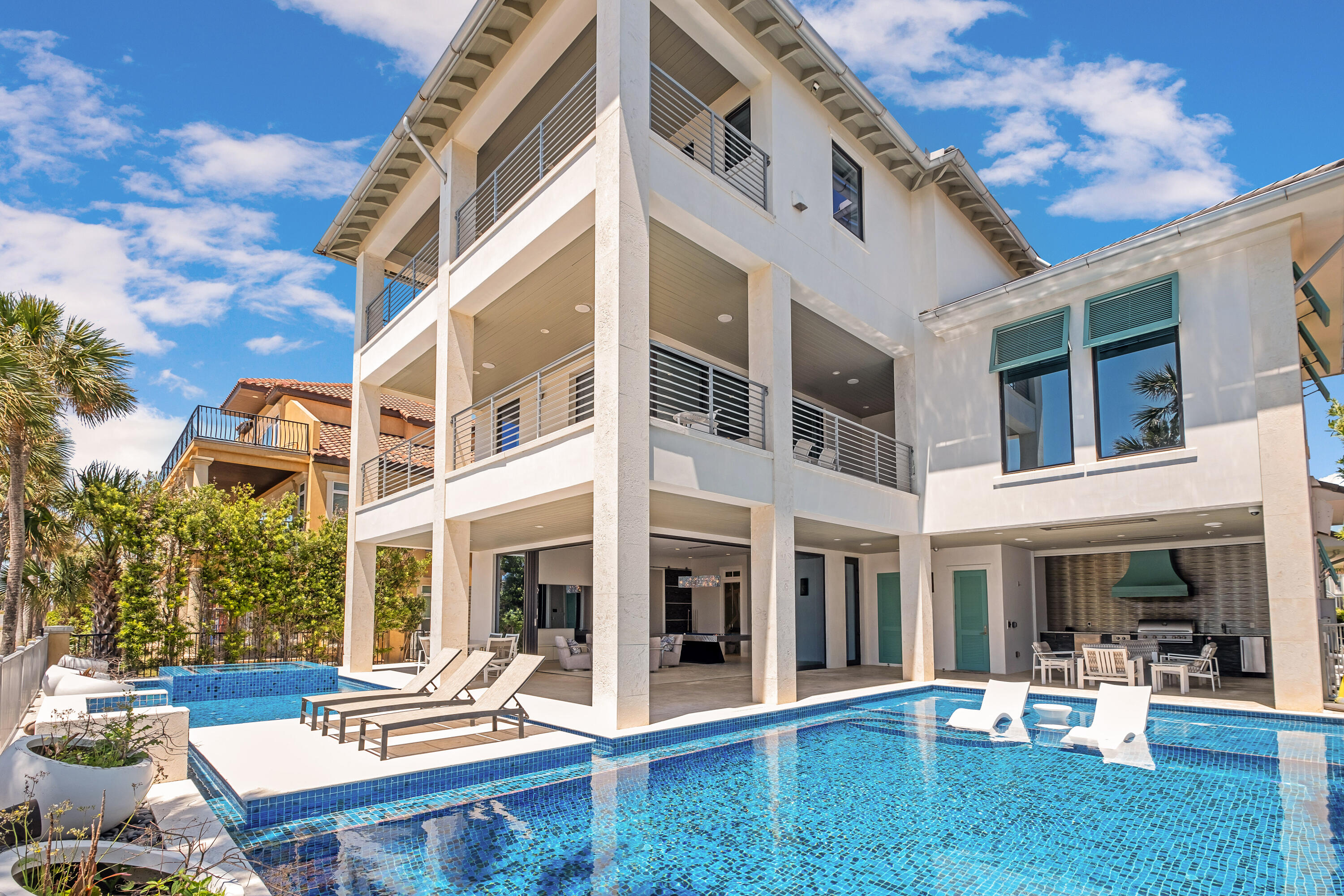 With both lake and Gulf views, this custom built contemporary home sits in the heart of Destin. Designed with entertaining in mind, this property spans 5819 square feet and maintains an easy indoor to outdoor flow. Both of the main living levels feature large, retractable glass doors that provide a full corner view of the exterior amenities and the Gulf of America. Dive into one of the largest, private swimming pools in the area, inclusive of water features and a sun shelf or dip your toes into the spa area and hot tub to relax. The exterior is equipped with a half bath, outdoor shower, fire features and custom grill area. Don't forget, the gated community of Destiny has amenities too inclusive of a swimming pool, fitness center, tennis courts, and is golf cart friendly! No expense was spared on the interior of this home. Upon entry you are greeted with a handmade stairwell with glass railing detail that was fabricated in Italy and is showcased on all three floors. The staircase wraps around a hand-blown Italian chandelier that is one of the true focal points of the residence. The bottom level has 4 Queen-sized built in beds with 2 full bathrooms, a King bedroom, and a laundry. This flooring, along with the pool deck, is tiled throughout to make an seamless look when transitioning spaces. This large living space is ideal for large gatherings! The second level features a Chef's kitchen with Wolf appliances, sub-zero refrigerator, and large island for food preparation. Cabinets are showcased with a hidden, sleek design. All countertops are granite throughout. The kitchen is open to the secondary living space and a large wrap around porch. On the second level there is also a King bedroom with en-suite and a half bathroom for guest use. The third level is considered to be the Primary Suite. With two bedrooms, two walk-in closets, two full bathrooms, a study, and a secondary laundry room for all partner needs. The en-suite is a showstopper with a deep soaking tub, walk-through shower, and hidden walk-in closet tucked behind closed doors. This closet features automatic lighting, remote pull down hangers, and a shoe-rotation rack. 

This property maintains a concrete structure, 3 HVAC units, 2 tankless Rania water heaters, a whole-house filtration system, generator, and is considered to be a Smart Home with an audio and lightening system, iPad controlled rooms via Control4, Sonos, and Lutron Smart Home Systems. All window coverings are also controlled remotely. Home to be sold furnished and short-term rentals are permitted.
