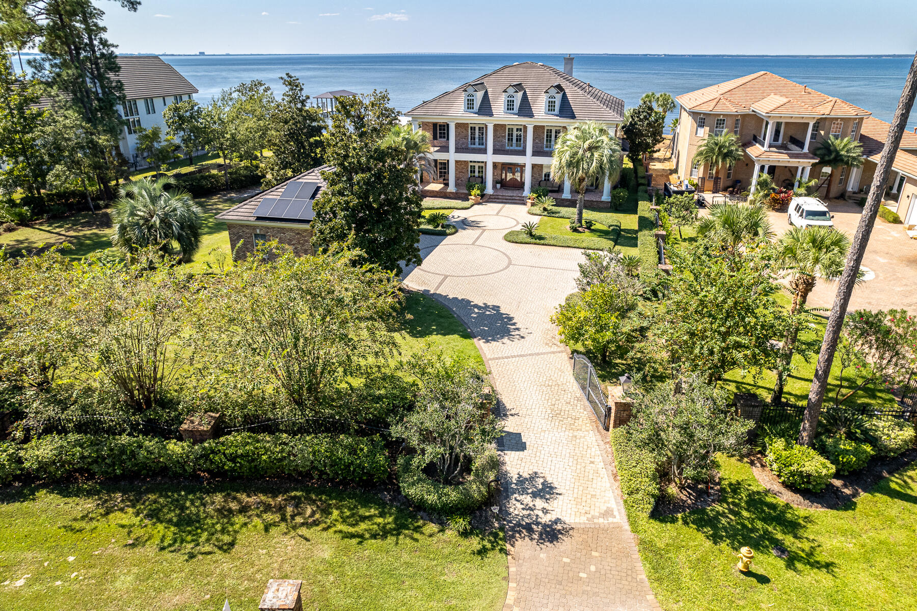 Majestic Bayfront estate with custom impressive details and an open floor plan where relaxedliving and southern hospitality flawlessly weave. Perfectly situated on nearly an acre on the Choctawhatchee Bay, this home boasts a gorgeous pool with a spacious patio, boat dock with lift, outdoor kitchen and bar area, private theater, gleaming hardwood flooring, and thoughtful details in every room. Double covered porches offer a shady place to unwind and enjoy year-round sunsets. Enter the gated driveway to lush landscaped grounds, complete with bountiful citrus trees and palms. The extra-large three car garage allows room for your leisure vehicle. Inside, a grand foyer opens to a sitting room and formal dining room with a butlers pantry leading to the kitchen.