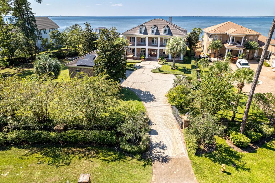 Majestic Bayfront estate with custom impressive details and an open floor plan where relaxedliving and southern hospitality flawlessly weave. Perfectly situated on nearly an acre on the Choctawhatchee Bay, this home boasts a gorgeous pool with a spacious patio, boat dock with lift, outdoor kitchen and bar area, private theater, gleaming hardwood flooring, and thoughtful details in every room. Double covered porches offer a shady place to unwind and enjoy year-round sunsets. Enter the gated driveway to lush landscaped grounds, complete with bountiful citrus trees and palms. The extra-large three car garage allows room for your leisure vehicle. Inside, a grand foyer opens to a sitting room and formal dining room with a butlers pantry leading to the kitchen.