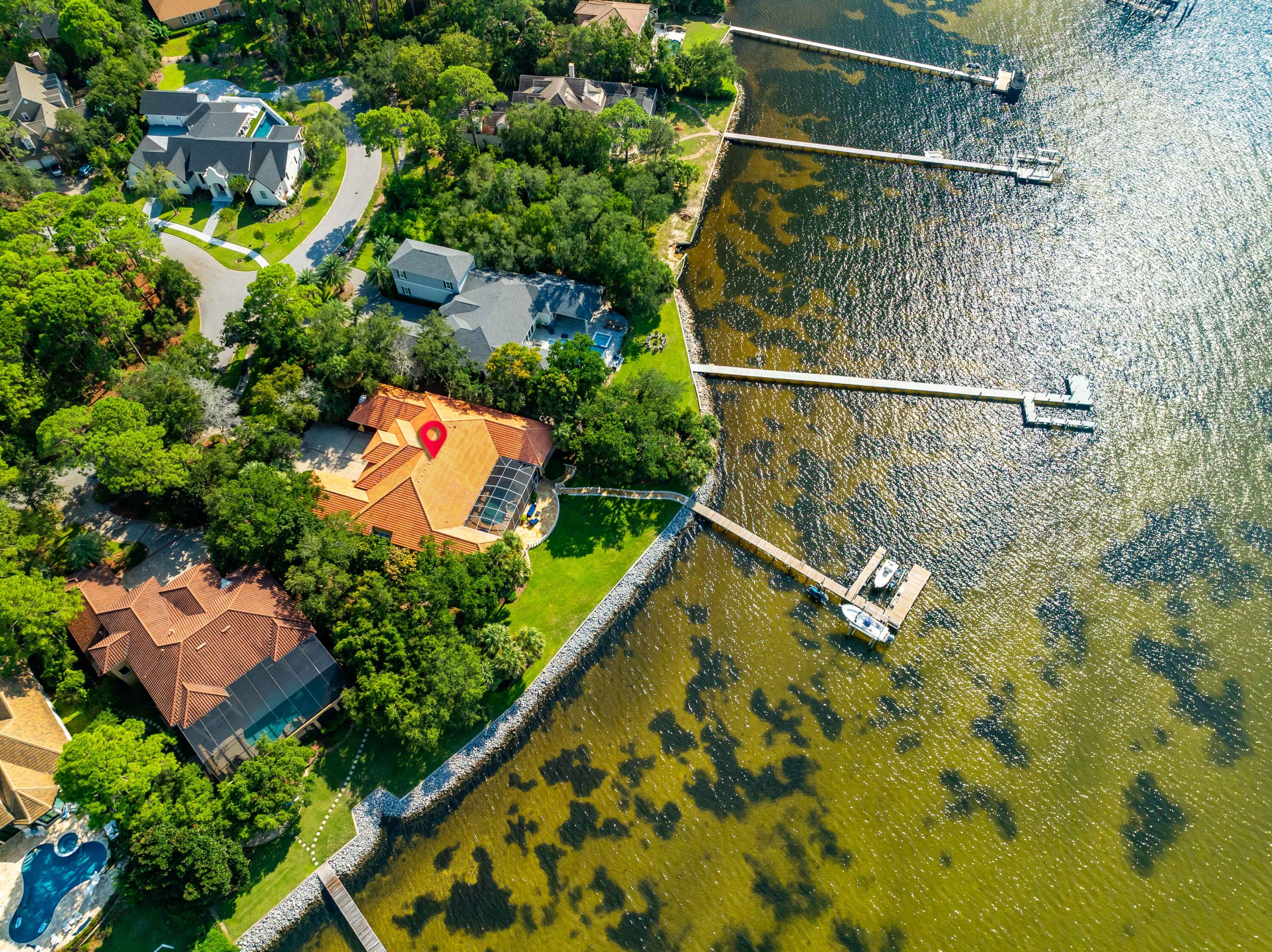 WESTWARD-FACING SINGLE-STORY WATERFRONT ESTATE WITHIN ESTEEMED GATED GOLF COMMUNITY PRICED UNDER $4M. Located in Destin's iconic Gated Community, Kelly Plantation, this 5 bed/6.5 bath Single-Story residence boasts 158' of Westward-facing Water Frontage on Choctawhatchee Bay. Equipped with a dock, 2 Boat Lifts, & a Jetski lift your backyard playground is boundless. The 63' screened-in back patio features a Saltwater Pool & Spa, outdoor kitchen, Outdoor Speakers, plus ample space for lounging and outdoor dining whilst admiring the view. Inside showcases the ultimate spacious open-concept living, with soaring ceiling heights ranging from 11' to 17' throughout the home. In addition to 5 bedrooms all with ensuite bathrooms, you'll find a sizable private Office. Upon entry, the Bayfront views serve as a picturesque backdrop to the Great Room's Soaring 17' Coffered Ceilings. Off of the Great Room you'll find the Formal Dining Room and lengthy Wetbar equipped with ample of storage,   Bar Seating, and Pocket Doors to enclose the space as a walk-in pantry for the kitchen. 
The open-concept Kitchen is abundant with countertop space, cabinet storage, and Natural Light dancing off the 14' ceilings. The elongated picture window offers an indoor/outdoor experience whilst in the kitchen. The adjacent spacious Family Room offers a cozy atmosphere with Bay Vews, Gas fireplace, and large sliding glass doors that create ease for indoor/outdoor living.  An impressive bowed picture window overlooks the pool area and backyard from the informal dining area. The large Office features 15' ceilings, a french door entry for privacy and 15' Ceilings. A convenient half bath services these communal areas. 
The Bayfront primary suite is a voluminous private retreat with tranquil water views and access to the back patio. With 14' Ceilings, space for additional seating, and His AND Her Private Bathrooms connected via a large Walk-in Closet. Her Bathroom is equipped with a Glam Station, Jacuzzi Tub, Separate Shower, private water closet, and linen storage. His bathroom contains a separate walk-in shower, water closet, storage, and respective access to the back patio. 
The 4 additional guest bedrooms are all equipped with ensuite bathrooms and 11' ceilings. A Dual-car garage and a Single-car garage allow for sheltered parking and additional storage space. The home's elongated driveway also offers substantial parking for the residence. 
Kelly Plantation offers an array of amenities, including an 18-hole Championship Golf Course, tennis courts, pickleball courts, two parks with play structures, walking and jogging trails, an equestrian center, a dog park, a fitness center, an owner's club with dining, and a community pool. You can also enjoy fishing in many ponds within the community. Just outside of Kelly Plantation, you'll find a plethora of restaurants, stores, and shopping options. And, you're only a few minutes from the incredible sugary white sands of the emerald coast.