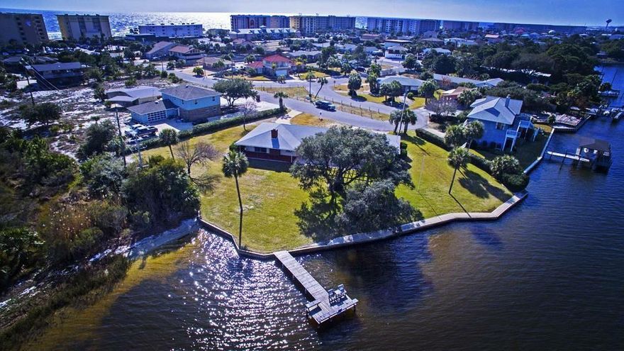 Looking for a beach home on one of the largest lots on Okaloosa Island? You have found it here! Island living at it's finest in this 3 Bedroom, 3 Bath home with 160' on Santa Rosa Sound and situated on 2 1/2 lots!! 200+ feet of gorgeous shoreline with a white sand beach area is perfect for sunning and swimming. Very short walk to the public beach access at the top of the street too. Lush, manicured lawn that you sink into perfect for viewing Billy Bowlegs, fireworks, and more that all happen directly in front of you. Great dock with built in seats to tie off your boat too. Nice open concept with new carpet and gorgeous refinished terrazzo flooring. Covered back porch area to sit in the nice breeze or watch the barges go by. Plenty of room to add on too. Call now!