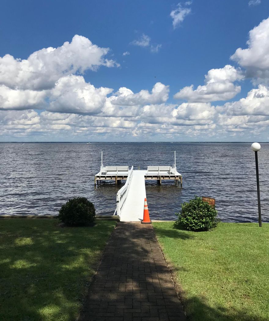 BAYFRONT COMMUNITY with Bay access IN THE HEART OF DESTIN! Beautiful ONE LEVEL townhome with one shared wall, no unit above! Upgrades include stainless steel appliances in kitchen (new in 2019), including induction stovetop/convection oven, washer and dryer (new in 2019), water heater (new in 2018), HVAC (new in 2017), and BRAND NEW ROOF IN 2021! Recent upgrades also include new kitchen cabinets and countertops including breakfast bar and bathrooms with new lighting, toilets and vanities! Handicap access to master bath with brand new porcelain tile shower. Loads of storage throughout, two closets in master, large closet in guest bedroom/office, storage under breakfast bar and two storage closets in screened in back porch! Tile floor throughout living areas and carpeted bedroom