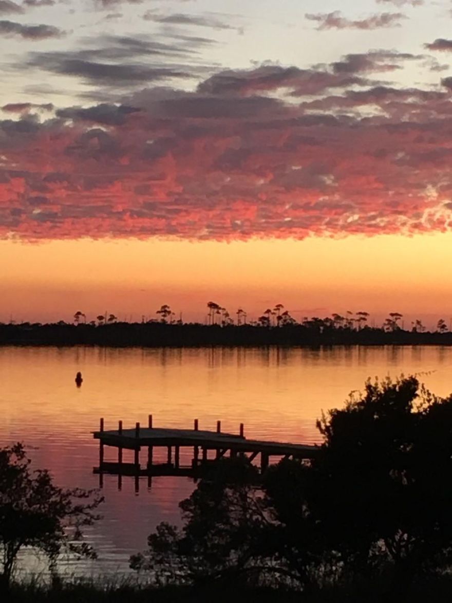 Live the lifestyle you have been dreaming about in this waterfront, gated community with NO Short Term Rentals. This ground floor unit enjoys views of the community pool, a private dock and the Intercoastal Waterway. Both the Living area and Master Bedroom have great views and walk-out sliding doors to the patio. Nice Master with sitting area, walk-in closet and en-suite bathroom. Only 5 stories with 35 units in this 'concrete' build condo building. Building sits back from the highway with ample parking for your extra vehicles and guest. This unit does have a deeded garage! Lots of long time owners here with strong HOA support and good solid financials.