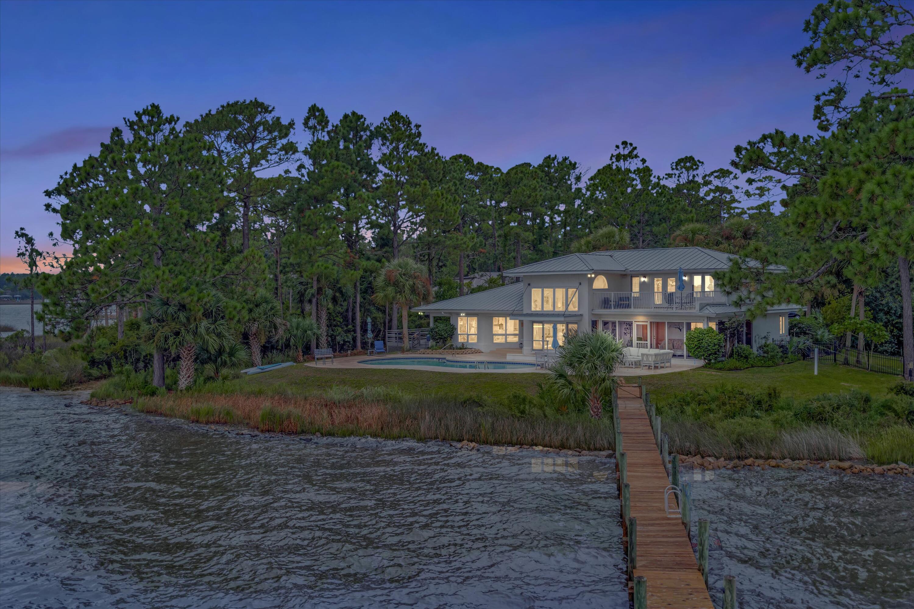 Coastal living at it's best ! This 1.2 acre bayfront property has the privacy, intimacy and space for extraordinary waterfront living. Bracketed with breathtaking sunrises and sunsets, approximately 121 ft of bayfront is complimented with boat dock, boat lift, sun deck, entertainment deck and gorgeous swimming pool overlooking all. The main house features stunning views of the bay from each of the three bedrooms with the second floor master enjoying a private balcony and the first floor bedrooms having a screened-in porch. While the main house is approximately 2,604 sq ft, for overnight guests there is a spacious separate 1 bdrm/1 bath apartment with 864 sq ft. The surrounding yard is lush with mature trees, tropical foliage and natural surroundings. New roof in 2018 w/25 yr warranty.