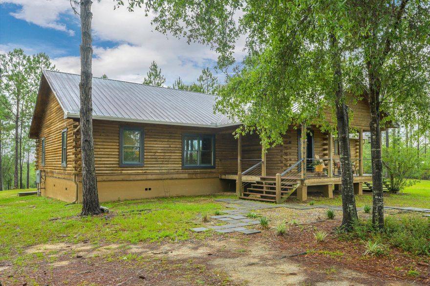 This exquisite log cabin is situated on a spacious 10-acre lot in a secluded area, offering tranquility and privacy. Despite its serene location, it is conveniently located less than ten minutes away from the interstate.The log cabin itself exudes a rustic and cozy atmosphere, with its handcrafted construction and warm wood finishes. The property boasts a unique feature--an enchanting custom tree house that adds a touch of adventure to the setting. As you enter the cabin, you are greeted by a generous living space that is perfect for gathering and entertaining. The kitchen has been tastefully updated with sleek quartz countertops, stainless steel appliances, and a convenient double oven.