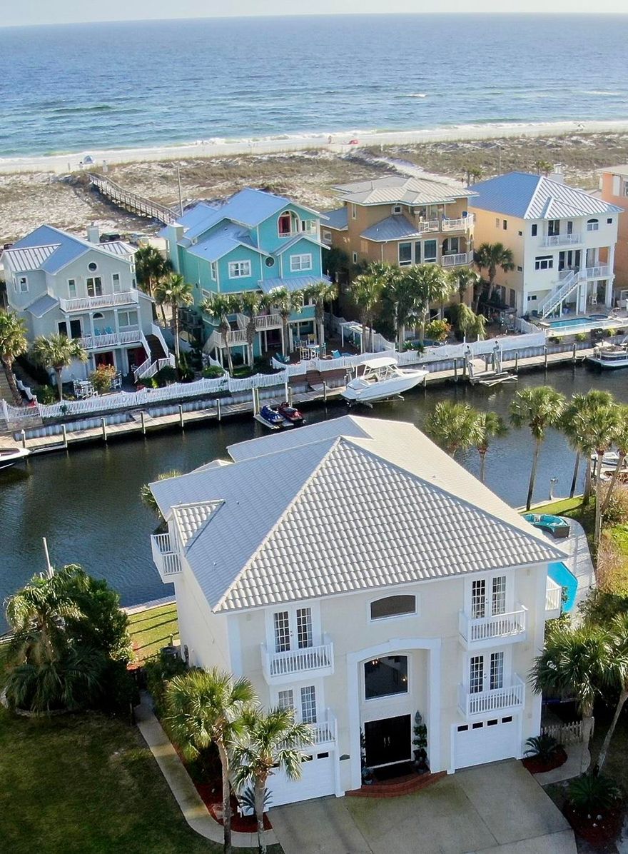 If you want water views from every room come take a look at this beautiful Mediterranean style four bedroom, three bath WATERFRONT home on desirable LAFITTE COVE! This three-story, canal front home is uniquely designed so that three bedrooms, two baths and the laundry are located on the second level. The third level features one bedroom, one bath with a very large open floorplan and 360 degree views of the sound, canal and Gulf of Mexico. Aside from the views, the home has Duraloc Tile metal roof system, which carries a 50 year, fully transferable warranty, and 140 mph wind coverage.(2005) Armstrong Luxe Plank waterproof flooring with a 30 year warranty.(2018) Elegant wrought iron, powder coat finish custom stair railing (2018), two new HVAC units. (2019)