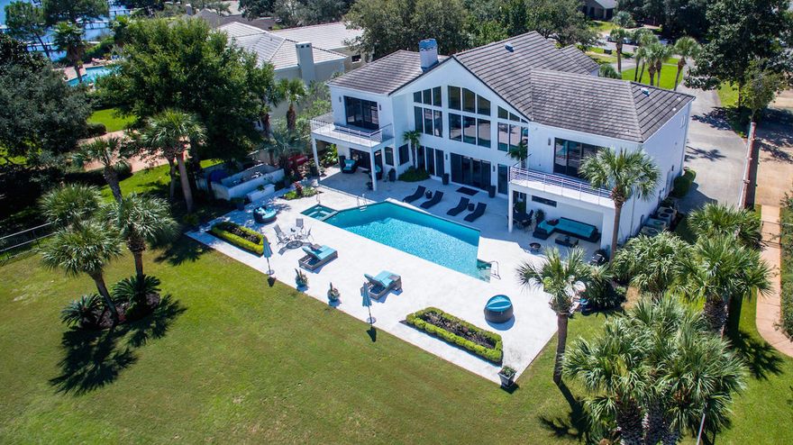 Spectacular contemporary home with 138' feet on deep-water Indian Bayou directly across from Choctawhatchee Bay! This gorgeous residence features a 2+ story wall of windows for stunning water views and abundant natural light throughout. The huge living/dining/bar area is fabulous for entertaining, especially as it leads directly out to the large patio, pool, yard, and boat dock. Impeccably designed, the finishes are beautiful, functional, and decorative. Of special note is the incredible cabinetry throughout the home, which beautifully keeps to the home's contemporary theme, ensuring a clean, minimalistic feel while providing an amazing amount of storage capacity!The floorplan is perfect for modern lifestyles. Just off the dining area is the fantastic European-style kitchen...
