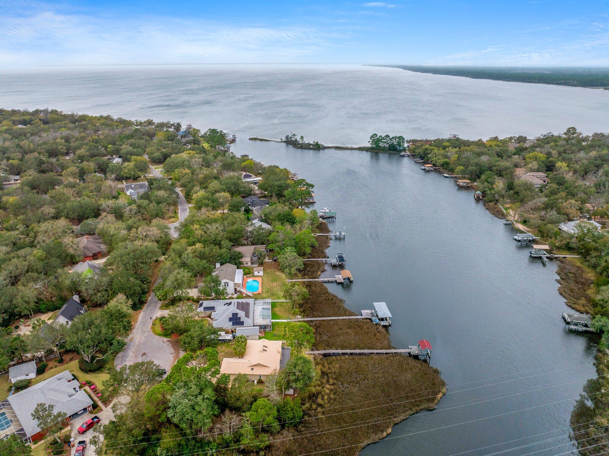 PRIVATE BOAT DOCK & BOAT LIFT!! Elegantly poised on the serene banks of the Bayou with direct access within minutes to East Bay Waters, this ranch-style residence embodies the essence of waterfront living. Boasting panoramic views from the living room, kitchen, master bedroom, and office, this home offers an unparalleled connection to the water. The property features a private pier leading to a personal boat dock equipped with a new lift system and remote control, ensuring immediate access to open waters. A new composite deck was built in January 2023 making this outdoor experience ideal for boating enthusiasts and those that like to spend their time outside. (see a full list of upgrades below) This home is nestled at the end of a cul-de-sac in the tranquil Mossy Cove neighborhood, this property promises a peaceful lifestyle with no HOA fees. Occupying a generous half-acre lot, this home is a haven of privacy for those seeking a quiet waterfront living experience. With this new Generac Generator installed in 2022, this home is protected as it will deliver power directly to your home's electrical system in the event of a storm. It is equipped with two liquid propane tanks that were installed as well for the generator (only). Home has a built in sprinkler system with a pump serviced by its own well.
Its thoughtful split-level design secures the utmost privacy for the master suite, complete with an en suite bathroom separate from the other two guest bedrooms and guest bathroom. Recent enhancements totaling over $34,000 elevate this living experience, including:
- New Deck with composite flooring and updated support (2023) - $14,000
- Generac Generator (2022) - $12,332 (including two propane tanks)
- Boat Lift with stainless steel cables, new belts, and remote control (2022) - $1,880
- Frigidaire Microwave Wall Oven Combo (February 2023) - $3,100
- Refrigerator (January 2021) - $2,674.00
- Dishwasher (June 2022) - $761.95
- Hot Water Heater (2021)
- Garbage Disposal (2022)