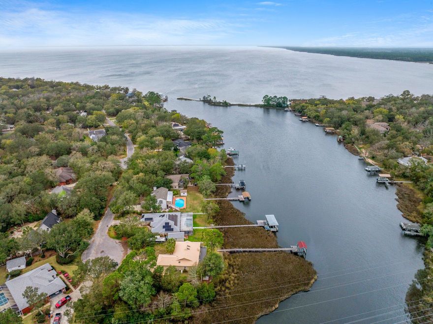 PRIVATE BOAT DOCK & BOAT LIFT!! Elegantly poised on the serene banks of the Bayou with direct access within minutes to East Bay Waters, this ranch-style residence embodies the essence of waterfront living. Boasting panoramic views from the living room, kitchen, master bedroom, and office, this home offers an unparalleled connection to the water. The property features a private pier leading to a personal boat dock equipped with a new lift system and remote control, ensuring immediate access to open waters. A new composite deck was built in January 2023 making this outdoor experience ideal for boating enthusiasts and those that like to spend their time outside. (see a full list of upgrades below) This home is nestled at the end of a cul-de-sac in the tranquil Mossy Cove neighborhood, this property promises a peaceful lifestyle with no HOA fees. Occupying a generous half-acre lot, this home is a haven of privacy for those seeking a quiet waterfront living experience. With this new Generac Generator installed in 2022, this home is protected as it will deliver power directly to your home's electrical system in the event of a storm. It is equipped with two liquid propane tanks that were installed as well for the generator (only). Home has a built in sprinkler system with a pump serviced by its own well.

Its thoughtful split-level design secures the utmost privacy for the master suite, complete with an en suite bathroom separate from the other two guest bedrooms and guest bathroom. Recent enhancements totaling over $34,000 elevate this living experience, including:

- New Deck with composite flooring and updated support (2023) - $14,000
- Generac Generator (2022) - $12,332 (including two propane tanks)
- Boat Lift with stainless steel cables, new belts, and remote control (2022) - $1,880
- Frigidaire Microwave Wall Oven Combo (February 2023) - $3,100
- Refrigerator (January 2021) - $2,674.00
- Dishwasher (June 2022) - $761.95
- Hot Water Heater (2021)
- Garbage Disposal (2022)