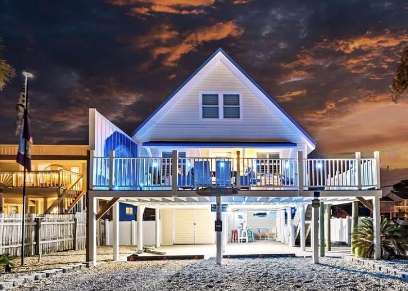 PRICE REDUCTION! Don't miss this one! Just a hop, skip, and a jump (or a quick ride) from the beach. Perfectly located right up the street from your favorite restaurants, fun parks or even a crawl home from the local beach bars! Get ready to embrace the ultimate coastal lifestyle in this stunning 4-bedroom, 2-bathroom home, perfectly positioned for breathtaking lagoon views and just a leisurely stroll to the Sugar Sandy Gulf Beaches! This gem is Turnkey ideal for your sun-soaked summer getaways or as a profitable rental investment. Equipped with luxury vinyl plank custom flooring throughout, a beautiful kitchen island complemented by a chic glass backsplash, and stainless-steel appliances that bring both elegance and functionality. Plus, enjoy the convenience of a full-size stackable tranquil lagoon and only three blocks from the sparkling Gulf. Dive into endless aquatic adventures and memorable beach days with family and friends! Outdoor Oasis set on a spacious corner lot, the vinyl-fenced backyard offers ample room for outdoor fun, barbecues, and lounging under the sun. You'll also appreciate the generous parking options with a covered garage (12.5' x 25') and an additional lock-out unit for your convenience. Boater's Paradise just blocks away from a community boat ramp, this home provides easy access for exploring the beautiful local waters with your boat! Convenient Amenities with delightful local restaurants and shopping options just around the corner, everything you need is within easy reach, making life a breeze! Modern Upgrades enjoy peace of mind with vinyl impact windows, stylish plantation shutters, a durable metal roof, and a composite front deck with elegant stairs that elevate the home's curb appeal. Fully Furnished this home comes furnished (minus personal items), ensuring a smooth transition into your new beachside lifestyle! Don't let this incredible opportunity slip away! Whether you're after a summer retreat, a lucrative rental investment, or your forever coastal home, this property is ready to make your dreams a reality. Contact us today for a private showing and step into your new coastal haven!