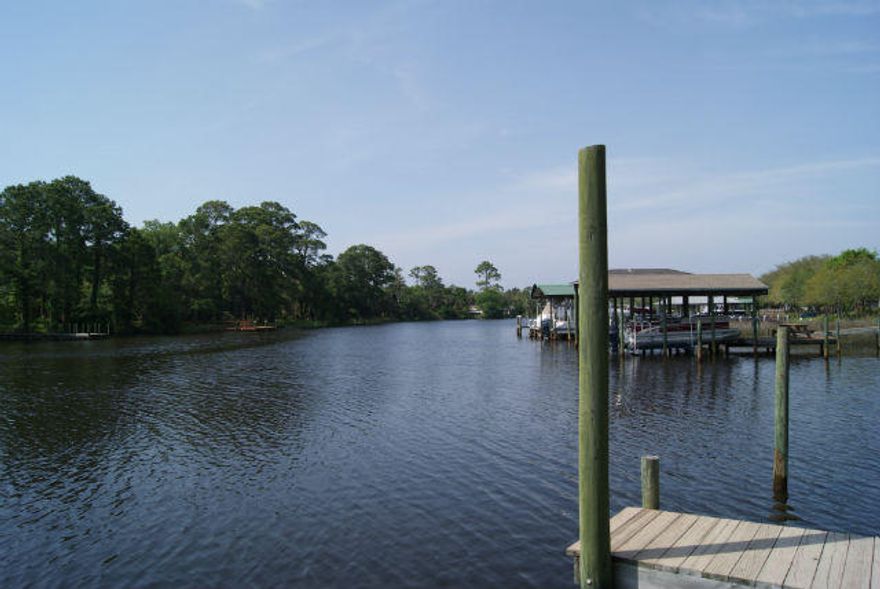 Fabulous waterfront living on the bayou convenient to all local amenities and complete with private dock. Quality construction is evident with travertine floors, vaulted ceilings, 6-inch exterior walls, gourmet kitchen, large master bedroom opening to 60ft deck with waterfront view. Separate dining room, breakfast room, study, play room, utility room and spacious garage. Brick paver driveway and dual separate heat pump units.
