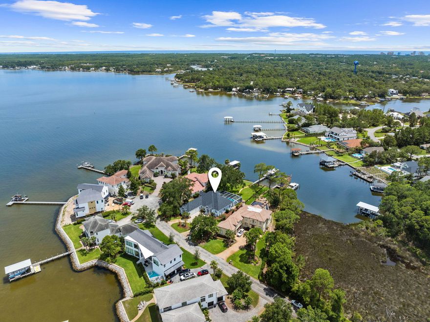 Experience the serenity of waterfront living at it's finest. Located in beautiful Grand Cove, a private community within Greater Driftwood Estates, less than 4 min. from Grand Blvd and 3 min. from Sacred Heart Hospital. Less than 1 mile from Burnt Pines GC. Brand new roof. Seawall rebuilt 2 years ago. 25' covered lit dock built in 2020 and warranted by Frank Davis. Boatlift holds 8K Lbs. Water is never less than 4'.  Spacious 3 car garage with a finished floor.  Large high quality cabinets and vaulted ceilings. Beautiful gas fireplace. 4 spacious bedrooms and baths. .Beautiful screened in swimming pool, betw deck resurfaced 18 months ago. 2 hot water heaters. a large dock with fish cleaning station, a covered boat lift for a 25ft boat and mooring for larger boats. Must see to appreciate