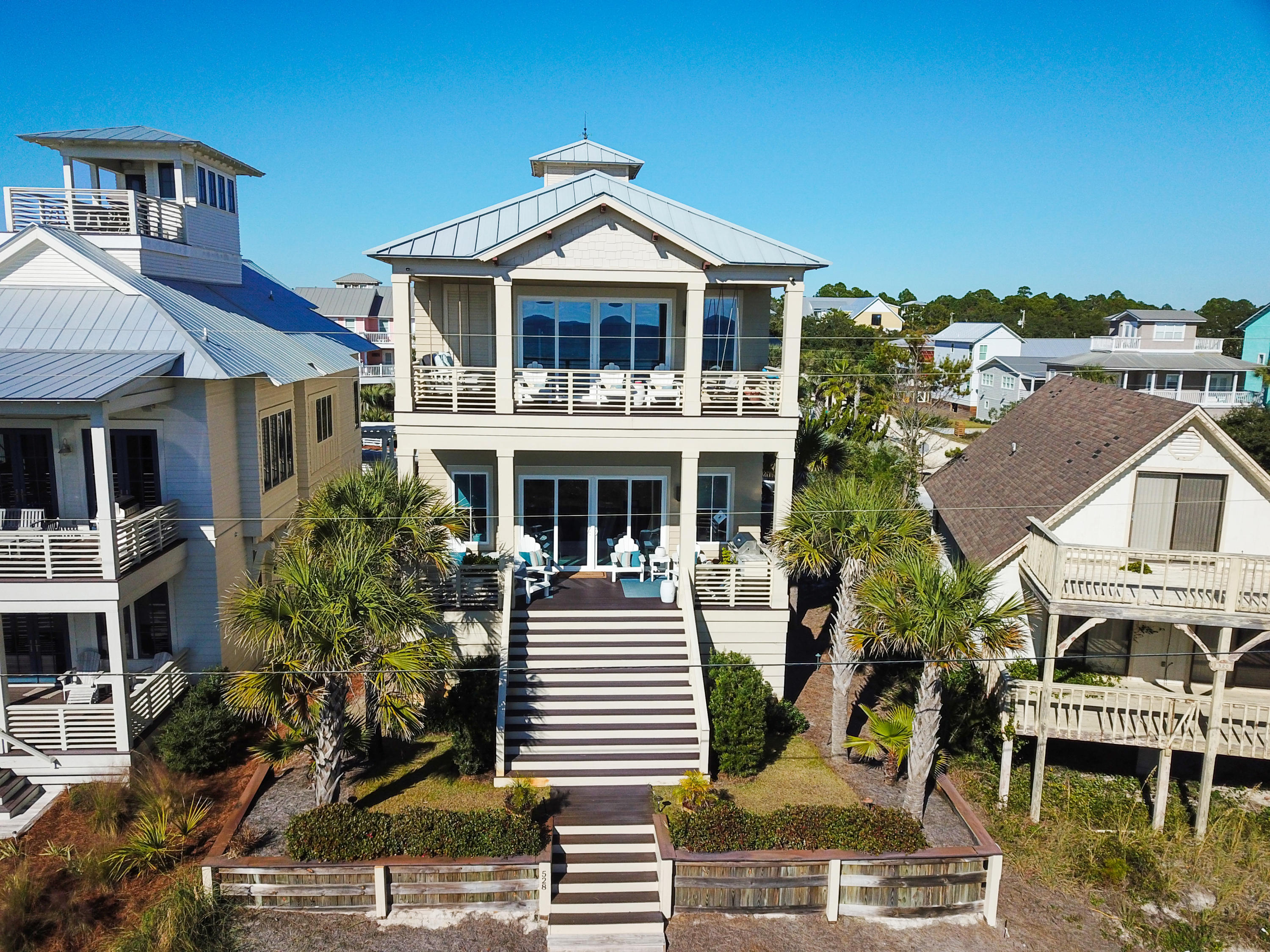 Now you can have it all: lifestyle, luxury, location with this Coastal retreat sited between the Gulf of Mexico and the Coastal Dune Lake, Eastern Lake. Offering incredible craftsmanship with modern amenities, this 5-bedroom, 4.5-bathroom estate with sweeping water views from all three levels. Stunning stone stacked fireplace and pecky cypress ceilings sets the tone for this masterful design and highlights the 4,021 sq ft open floor plan.The great room opens to the rear patio, steps from the sugar sand and is the perfect balance of casual and elegance - ideal for entertaining large crowds or an intimate dinner party. The sleek Chef's kitchen will satisfy everyone with professional grade appliances complimented by the marble countertops atop an oversized center island and custom