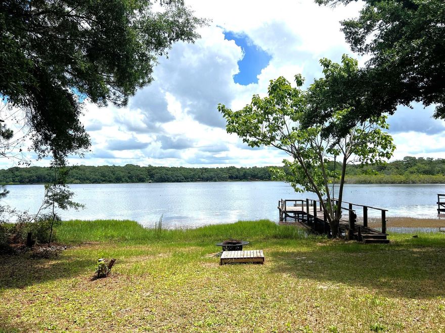 Great opportunity on this beautiful lakefront manufactured home on Kings Lake. Spacious home with covered front & back porches, attached 14x16 carport, detached 20x18 garage/shop & private dock. Interior features an open floor plan, large living room with woodburning fireplace, updated master bath & a 10x32 sunroom overlooking the lake, which is in addition to the H&C SF. A cedar lined storage room sits off the sunroom & additional storage located outside the home, off the side porch. Metal roof replaced in 2012. New fridge and Lennox HVAC system in 2023. Outside boasts beautiful hardwoods, azaleas, pear & low quat trees, blueberry bushes, fenced area in back yard for your pets. Utilities include public water and septic tank. This one won't last long, so schedule your showing today!