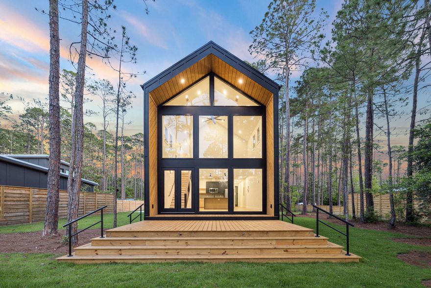Set on a private 1/3-acre lot and backing directly to 20 acres of untouched state forest, this striking new construction offers a rare blend of modern design and tranquil natural surroundings -- with no HOA restrictions.Inside, you'll find 3 bedrooms, 2.5 bathrooms, and 1,220 square feet of thoughtfully designed living space, all framed by soaring 23-foot ceilings and a dramatic wall of Anderson windows that flood the home with natural light and provide panoramic views of the forest. White oak LVP flooring runs throughout the main living areas, adding warmth to the sleek, contemporary finishes.The kitchen and open-concept layout flow seamlessly into the spacious living room, while upstairs bedrooms offer privacy and views through oversized windows. Tiled bathrooms bring a clean designer touch, and the modern architectural lines give this home standout curb appeal.

Outdoors, enjoy a fully landscaped yard with irrigation, a large driveway with ample parking, and a privacy fence for added seclusion. The expansive back deck invites you to relax or entertain while immersed in the sights and sounds of nature.

Located just minutes from Topsail Hill Preserve State Park, local trails, and the beaches of 30A, this home is on public water and sewer and move-in ready.