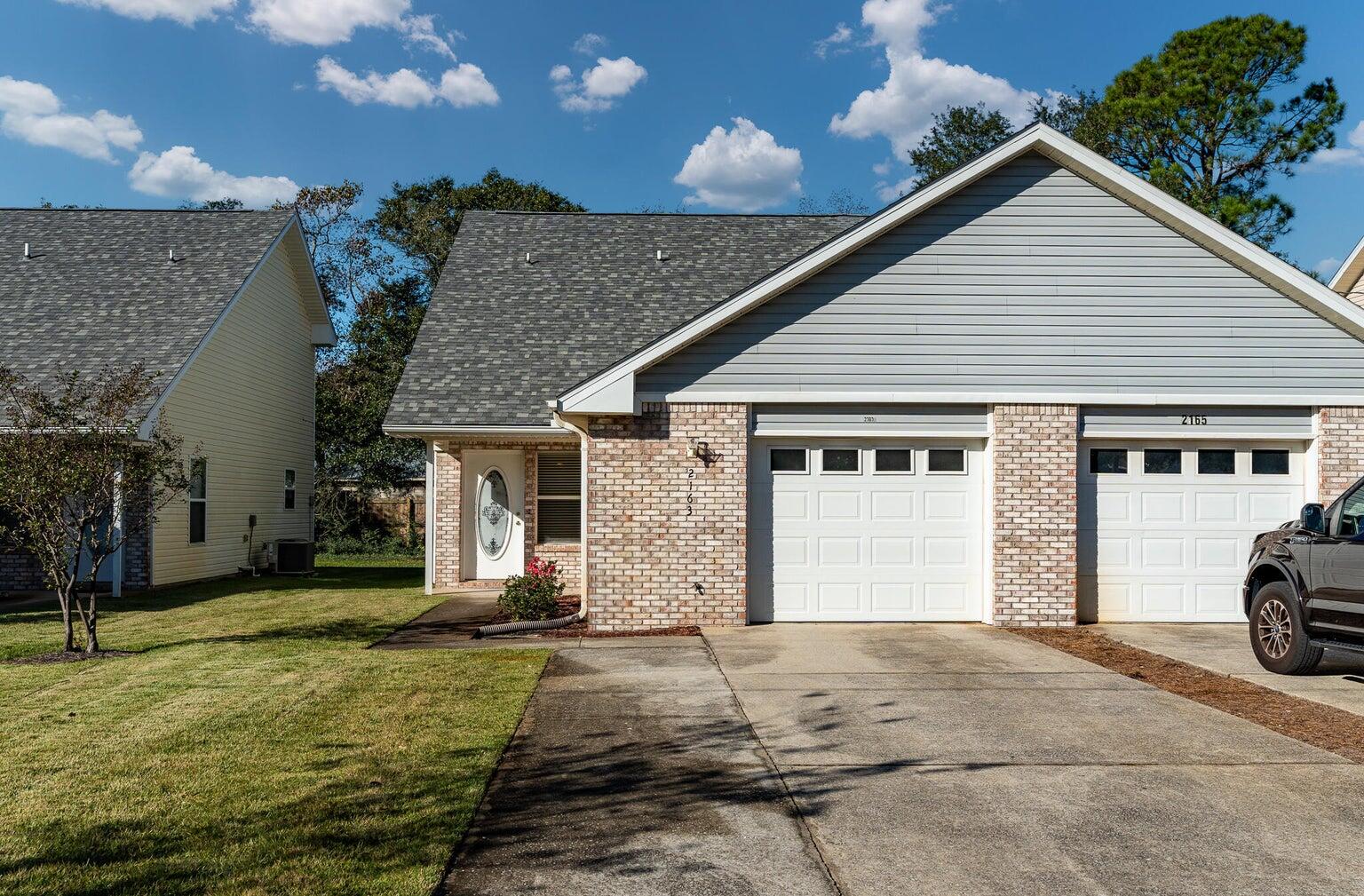 Discover one of the most affordable homes in East Navarre, ideally located just 8 miles from Hurlburt Field and minutes from the pristine white sands of Navarre Beach. This charming residence features an open-concept living area, perfect for modern living. The bright kitchen is equipped with a breakfast bar, pantry, built-in microwave, and electric stove. The spacious primary bedroom, located on the first floor, offers ample space for your furnishings. Upstairs, enjoy the privacy of two generously sized bedrooms accompanied by a full bathroom. The washer and dryer hookups are conveniently located in the garage. Step outside to the back patio, an ideal spot for grilling and enjoying the outdoor space. Notable updates include a new roof installed in 2021 and a water heater from 2012.
