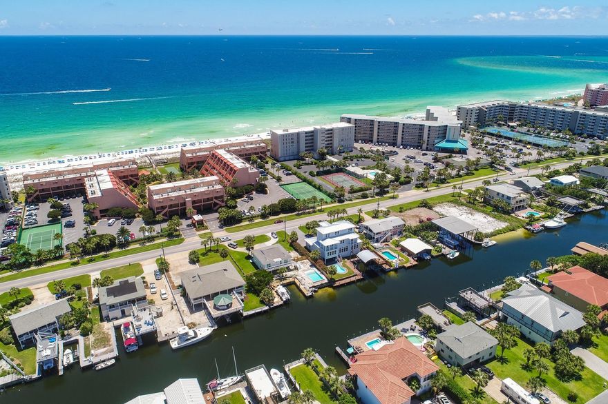 ONE OF THE BEST PPSF IN ALL OF HOLIDAY ISLE! Been waiting for a waterfront home with boat slips and direct access to the prestigious Destin Harbor and beautiful Gulf of Mexico? This is your chance to own a 6-bedroom spacious home with a prime location in Holiday Isle. Experience the coastal lifestyle to the fullest with an expansive entertainment deck including a gazebo service bar & summer kitchen. Take in views of the canal and Destin Harbor from the open deck, relax in the sunshine, or stay cool under the covered balcony. This home is unique not only because it has two huge boat slips on deep water (enough room for multiple boats) but you also have four waterfront bedrooms along with 2 additional guest bedrooms. The beach access is conveniently located just across the street. The upper level has just been updated with brand new wood flooring (high-end laminate) throughout the living & dining area. Beautiful granite countertops were just added with a large breakfast bar, perfect for casual dining. Rooms are spacious and there are waterfront master bedrooms on each level with en-suite bathrooms. There is also a waterfront living area on each level, so this is a great floor plan for a vacation rental or large families. Sliding glass doors throughout the home bring the outside views in for true waterfront living. There is a very spacious two car garage with coated concrete, which maintains well with the elements. Plenty of room to store a golf cart, paddle boards, fishing and beach gear! There are many conveniences near the home like great restaurants, shopping and entertainment options. This is the perfect place to experience all that Destin has to offer including world class fishing, boating, snorkeling the Destin Jetty's and more. Great community with security and minimal HOA fees - only $300 annually. Don't miss out on this great opportunity to own a home with 90 feet of frontage on a deep water canal.