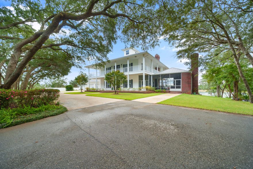 Stunning Southern Lakefront Estate on 32 Acres with 360 Water Views! Nestled just north of Panama City, Florida, this extraordinary 32-acre estate on freshwater River Pond is a remarkable gem. As you enter this lakefront estate, you're greeted by a scenic 100+ year oak tree-lined road leading you to a stunning 7,200 sq. ft. Southern-style home, perfectly positioned on the end of a peninsula offering breathtaking 360-degree lakefront views. Designed for both luxury and function, this 5-bed, 5-full bath, 2-half bath residence boasts show-stopping wrap-around porches on all levels, mother-in-law suite, & incredible 10-foot ceilings throughout all three levels. Two upper levels at 4,000 SF, walk-out basement at 2,000 SF, heated/cooled storage at 1,200 SF. Enjoy the ease of access with a full-size elevator, making every part of this home effortless reachable.

As you step into this Southern retreat, you're greeted with a formal dining room and spacious sitting room that would also be great for a home office. This home exudes timeless charm and modern luxury. Enter through the foyer and your eye is drawn directly to the French doors leading onto the covered porches where you'll enjoy impressive lake views and exceptional sunsets year-round. 

The main level of the home features an expansive chef's kitchen with quartz countertops, adjacent bar and a walk-in pantry. A cozy fireplace anchors the living room and is enhanced by French doors leading to stunning waterfront views. This main level also provides direct access to the screened-in summer kitchen designed for seamless indoor-outdoor entertaining. A powder room is also found on this level as well as the elevator for easy access to the upper and lower levels. 

The upper level of the home features a spacious primary retreat with a walk-in shower, soaking tub, double vanities with ample counter space and custom walk-in closet. This level also hosts the laundry room, two additional bedrooms and two baths and direct access to the covered porches on the front of the home overlooking the gorgeous oak trees. 

The lower level of the home is a true walk-out basement but don't let the name basement fool you. This level has 10' ceilings just as the two upper levels and features a full kitchen, spacious kitchen island, living room with fireplace, home theater room made for entertaining, and two additional bedrooms and two bathrooms--making the ideal setup for guests or multi-generational living. Access to the covered porch is just off the living room area through French doors and you're just steps away from the shores of the lake. The lower level also provides an expansive 1,200 sq. ft. heated & cooled storage room--perfect or storing hunting & fishing gear or for crafting & hobbies. 

Next to the home you'll find a detached 3-car garage for ample storage and parking along with a circular driveway for easy access of multiple vehicles. The ultimate outdoor paradise is what you'll call this retreat. This freshwater lake is ideal for fishing, tubing, and water skiing, offering a serene and secluded lifestyle just 20 minutes from town. With plenty of space for ATVs, side-by-sides, and outdoor adventures, this is a true country retreat, designed for families to grow for generations to come. 

Built solid with poured concrete construction, this fortress of a home on the lakefront is as durable as it is breathtaking, with classic white horizontal clad siding and red brick accents completing its timeless Southern charm. As you sit on the porches from all sides, you're mesmerized by the shade the stunning oak trees offer and the charm that Spanish moss provides. This property has been impeccably maintained by its original owner and no detail has been left untouched. Remarkable landscaping spans the entire property so you can enjoy every aspect of this lakefront retreat. Don't miss this rare opportunity to own a luxury waterfront estate in the heart of N. Bay County where this particular home is extraordinary with encompassing the entire peninsula on the lake.