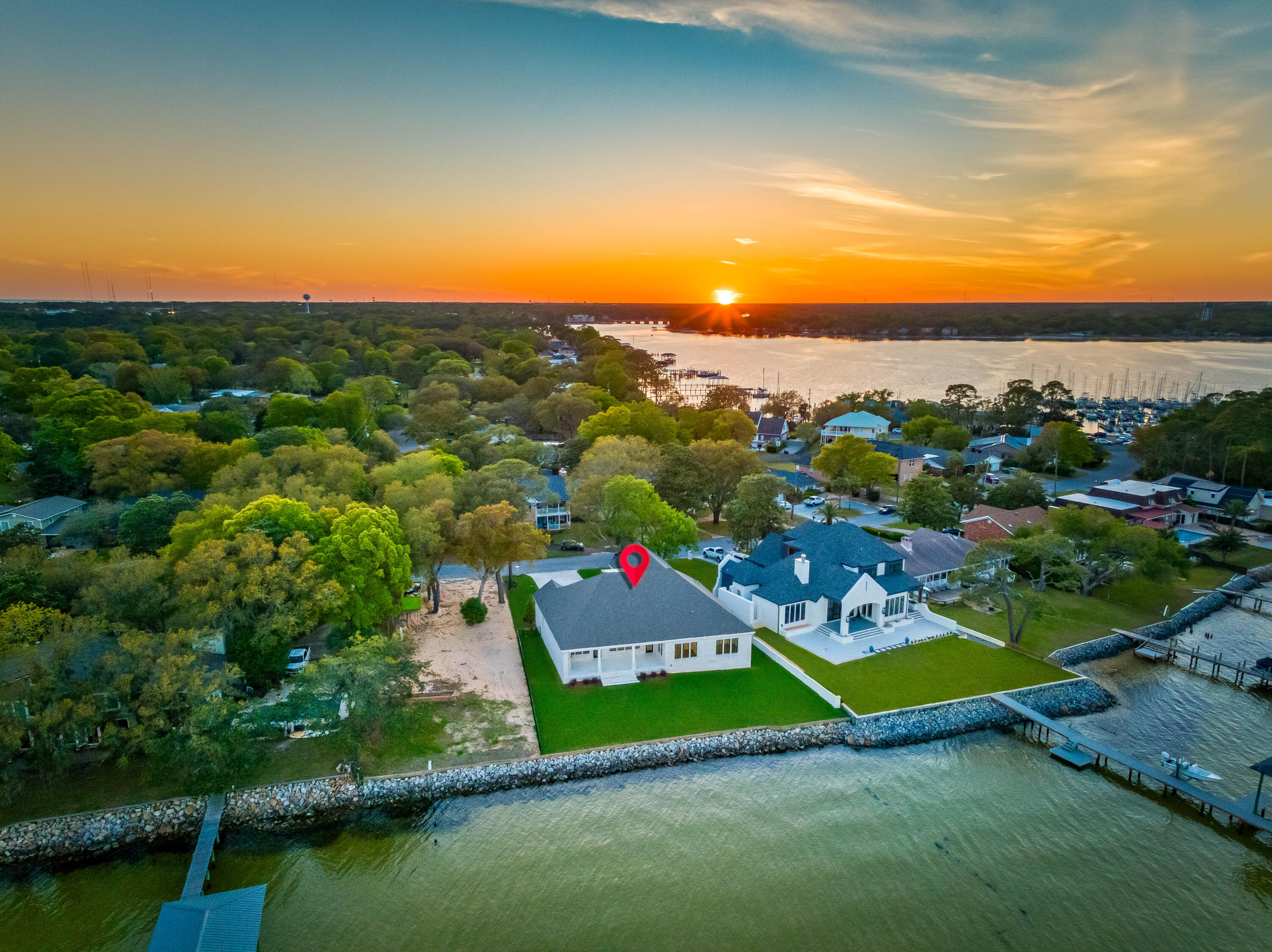 BRAND NEW LUXURY BAY FRONT PARADISE WITH 107 FEET ON THE CHOCTAWHATCEE BAY WITH SPACE FOR A POOL! This New 2024 Build boasts breathtaking views of the Bay & Destin's iconic Emerald Grand. It's prime location features the best Sunrises and Fort Walton Beach Yacht Club nearby.The elegant entry foyer greets you as you enter and sets the tone for the entire residence. The 10' ceilings, LVP flooring, open floor plan all seamlessly combine the living, dining, and kitchen areas, all with PANORAMIC views of the Bay. The cozy outdoor fireplace, makes it easy to enjoy the waterfront scenery.The Chefs kitchen is equipped with Thermador appliances, a full size fridge and freezer, a 48' gas range and an over sized island. A wet bar with an ice maker, beverage cooler add luxury and convenience.