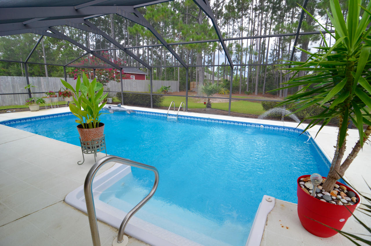 The BEST priced POOL home in Holley by the Sea. This meticulously landscaped all Brick home features a screened in 15x30 in-ground heated pool and side entry garage with extended driveway for extra parking. The interior features 4 bedrooms, 2 bathrooms, raised ceilings, eat in kitchen with stainless steel appliances and an island, separate dining room, spacious living room leading to the lanai covered pool and plenty of outdoor space. Additional features include a private back yard, 100x200 lot, storage shed, hurricane shutters, palm trees and more. Priced to sell, this is truly a must see home.