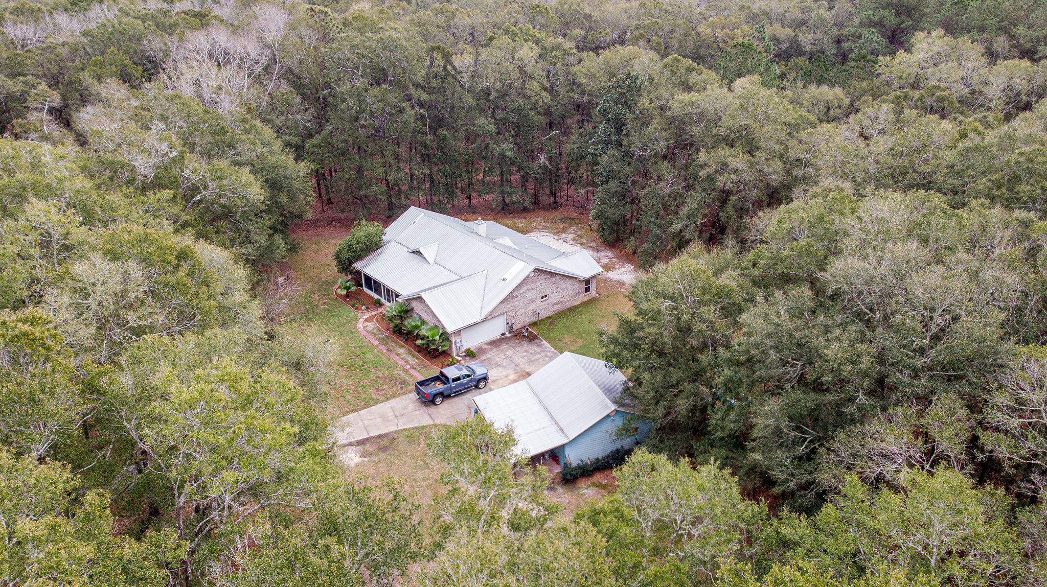 WOW-fully fenced parcel with single level home nestled among the trees with pasture for horses, room to 4-wheel, garage space for 4 cars and close to 331 to get south of the bay & to the beach is waiting for you. The moment you enter you are welcomed with open space & light! This home is perfect for family & friends to gather with open floor plan with large kitchen area that opens into great room & dining area. A wood burning stove gets the home nice & ''toasty.'' The screened porch off the living area, offers a cool summer sitting area and more space to relax. The spacious master is located on one side of the house with a large walk in closet. The opposite side of the house offers 2 bedrooms and full bath. When it comes to the outside