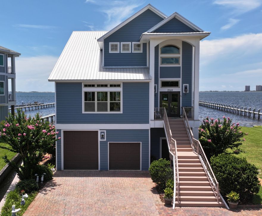 Welcome to your dream home, in gated community of Sea Shadow! Perfectly positioned with panoramic views of the Santa Rosa Sound and Tiger Point Golf Course, this extraordinary residence was crafted for those who love to entertain. Step inside to soaring 12-foot ceilings and walls of impact-rated glass that flood the space with natural light and showcase sweeping vistas of the Intracoastal Waterway and National Seashore. Sliding doors open to a private balcony--your front-row seat to breathtaking sunrises/sunsets, Blue Angel shows and the tranquil rhythm of coastal life. A chef's dream kitchen awaits--spacious, well-equipped, and designed with gatherings in mind. Enjoy double wall ovens, two refrigerators, expansive counters, abundant cabinetry, a breakfast bar, and space for a large dining  table. All of it comes with a stunning view. The open-concept great room features rich, wood-look tile flooring, plus access to the waterfront balconyideal for seamless indoor-outdoor living. The main-level owner's suite is a sanctuary of space and serenity, offering private balcony access and awe-inspiring views. The updated ensuite bath pampers with a luxurious oversized tile shower, beautiful finishes, a bench, and multiple shower heads. Also on the main level: a well-appointed office with built-in cabinetry, as well as an updated powder room. A private elevator services all three levels, making daily living and entertaining effortless. Upstairs, you'll find a versatile loft space overlooking the tranquil ponds of Tiger Point Golf Courseperfect for a den, or creative studio. Two massive bedrooms with walk-in closets face the Sound, and a third good sized bedroom. The upstairs bath has been fully remodeled with elegant Carrera subway tile throughout the walk-in shower and tub surround. Private dock, boat lift, two jet ski lift, extra boat slip, and pier to enjoy ever changing coastal views. Laundry room has a pet washing station. So many extras! Live in Paradise!!!