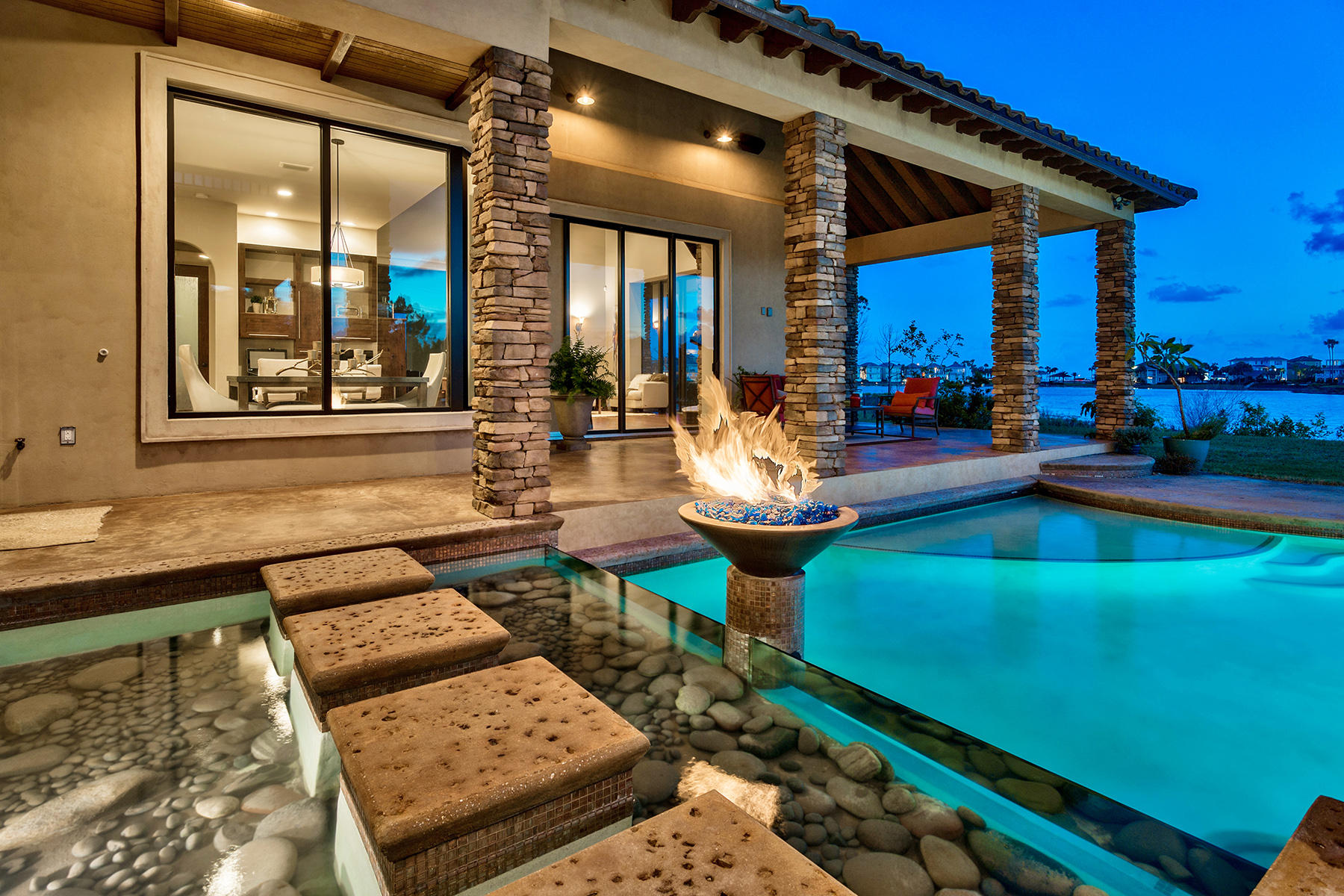 Presiding over 225' of pristine lake frontage and capturing stunning gulf views, this masterfully built Fortified Concrete Construction home was thoughtfully constructed by Babin Builders and strategically occupies over half an acre of privacy located in the beautiful gated enclave of Destiny East. This extraordinary home is both elegant and highly functional with pristine Mediterranean design juxtaposed California contemporary outfitted with notable features such as a solid cypress suspended floating staircase, floor to ceiling glass windows allowing optimal water views from every living space, sprawling covered porches and elevated pool area complete with an adjoining spa and water feature as well as a natural gas fire obelisk for added ambience.
