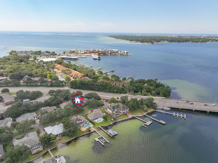 Nestled along the pristine shores of Choctawhatchee Bay in Shalimar, this exceptional waterfront masterpiece defines luxury living. A symphony of architectural brilliance and natural beauty, this 5-bedroom, 6-bathroom sanctuary offers an unparalleled lifestyle within a generous 3700+ square feet. As you step through the grand entrance, you're greeted by a fly staircase and crystal chandelier. To the left is a formal dining room complete with a chandelier, oak flooring, and built-in cabinets with glass shelving. Every inch of the living space is flooded with natural light by day and well-planned recessed lighting by night. The kitchen connects to the main living area and features a breakfast bar and center island that invites both culinary creativity and social gatherings. The adjoining breakfast nook offers breathtaking views of the shimmering waters, making every meal a feast for the senses. The primary suite is a true retreat on the first floor, boasting water views and a spa-like en-suite bathroom that beckons relaxation. The downstairs patio extends the room into the great outdoors for a quiet morning coffee retreat and sunset views. Each of the additional four bedrooms is generously appointed, providing comfort and privacy for family and guests. Two of the bedroom share a Jack and Jill bathroom with private water closets. The other two bedrooms feature built-in storage and have easy access to a full bathroom at the end of the hall. Outside, a private oasis awaits. The sprawling backyard leads to a private dock, a gateway to endless waterfront adventures. Whether you're an avid boater or simply appreciate the tranquility of the water, this feature sets this property apart as a true coastal gem. The dock includes a 26,000 pound boat lift with water and power connections on all four corners. The outdoor living spaces are as awe-inspiring as the interior, with a covered patio, a meticulously landscaped garden, and a gunite pool that seemingly blends into the bay. Relax while enjoying the gentle sea breeze or entertain in style against the backdrop of a mesmerizing sunset. This luxury residence is not just a home; it's a lifestyle statement, an embodiment of sophistication and leisure. Located in the community of Shalimar, you'll have convenient proximity to the heart of the city. Enjoy a quick drive into Fort Walton Beach and Destin for the stunning Emerald Coast beaches, shopping, and dining.