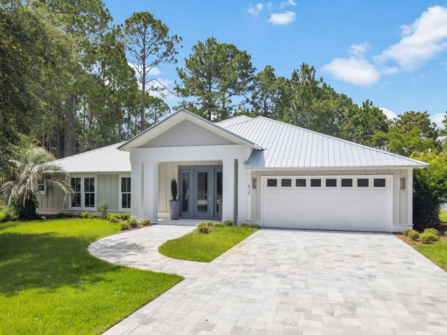 Tucked within the enchanting Sugarwood Beach community, this newly built coastal retreat offers over 3,200 square feet of refined, single-level living. Designed with effortless flow and coastal elegance in mind, it welcomes you with an open-concept layout where natural light, designer touches, and thoughtful finishes abound.The living room is warm and inviting, with a glowing fireplace and large windows that capture coastal breezes. Whether you're entertaining guests or savoring quiet moments, the space feels both sophisticated and serene.The kitchen is a true standout--anchored by a grand island, quartz countertops, mosaic tile, and top-tier Frigidaire professional appliances. It's a place made for gathering, cooking, and creating memories.