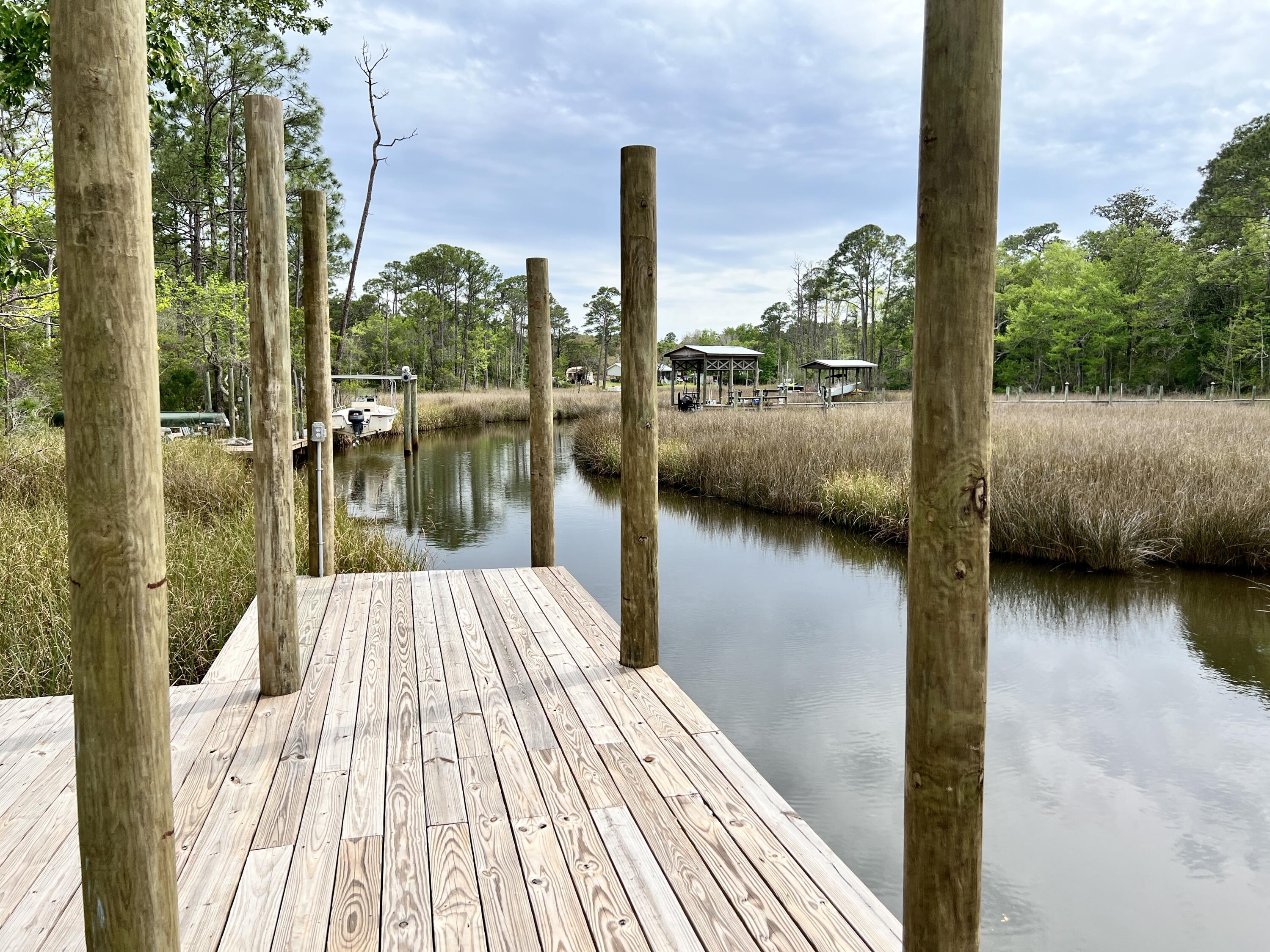 Enjoy privacy & nature's beauty with this spacious property located in the gated community of Mussett Bayou Estates! This gorgeous, 5 bedroom/2.5 bath home showcases several amenities throughout its nearly 2,700 sq ft. The interior features an open floor plan, vaulted ceilings, granite countertops, stainless steel appliances, beautiful tile flooring in living areas, two dining areas, heated/cooled garage & sun room. The exterior features several upgrades including a saltwater pool, fenced backyard, covered porch with outside shower, & a 180' elevated walkway through the natural area to the dock and boat lift on a protected, deep waterfront at the back of the property. The property is within a short drive of the Sandestin/Miramar Beach area, the start of 30A & the junction of FL-331/US-98.
