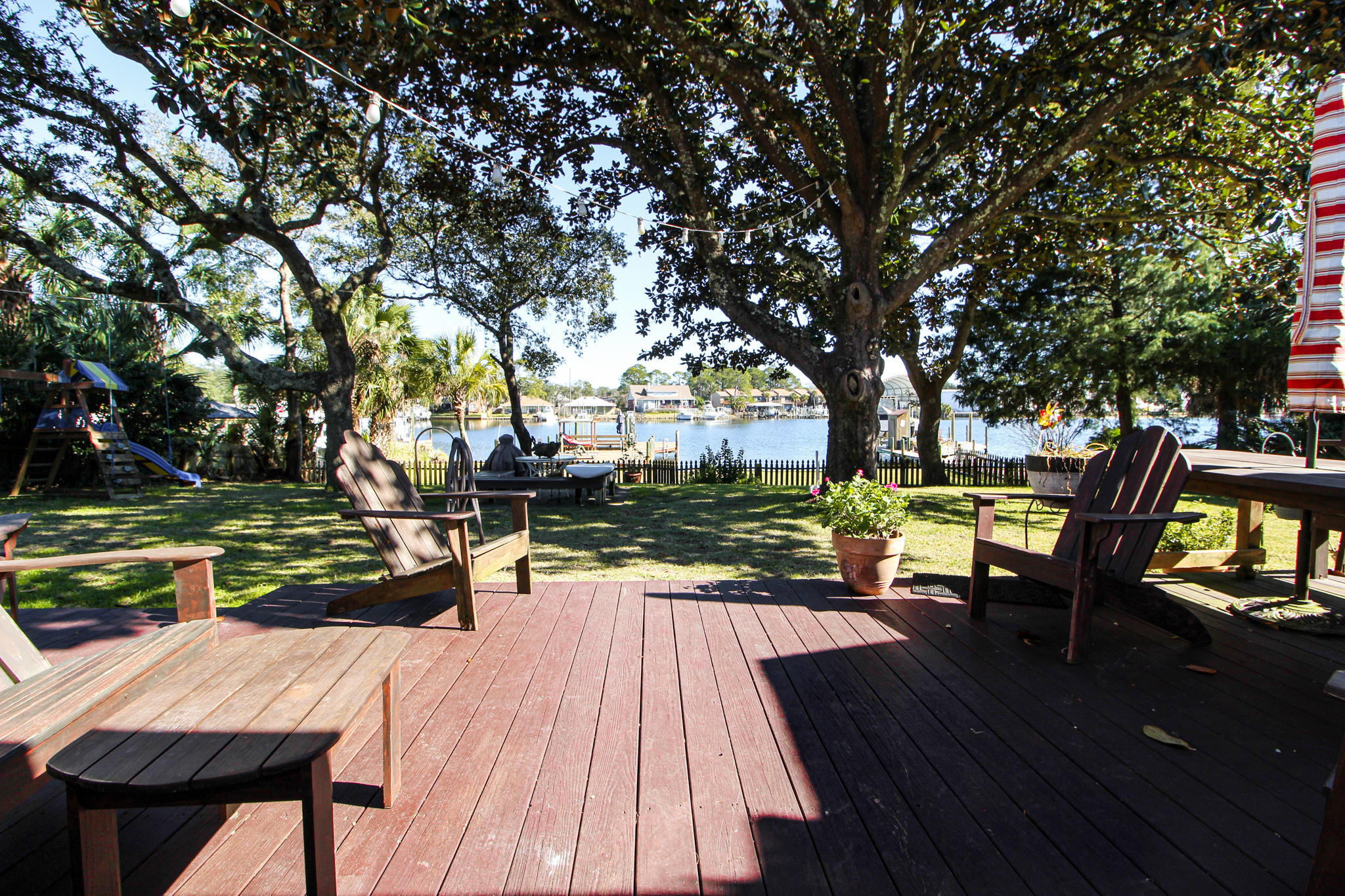 ENJOY WATERFRONT LIVING EVERYDAY! You will be delightfully surprised as you step into the tiled foyer with amazing water views. Spacious living room offers you comfortable living with fireplace with custom mantle, tiled hearth, beautiful hardwood flooring, and french doors that lead out to the deck area and backyard. Dining area is separate by columns adjoining the living room making it easy to entertain. Kitchen will delight any cook with lots of corian counter space, white washed brick backsplash, some cabinets with glass fronts, stainless steel appliances to include a gas stove and a electric oven that can be separated into a small or large oven, large center island with breakfast bar and a built-in desk area that is very functional. Dreamy master bedroom with shiplap walls and