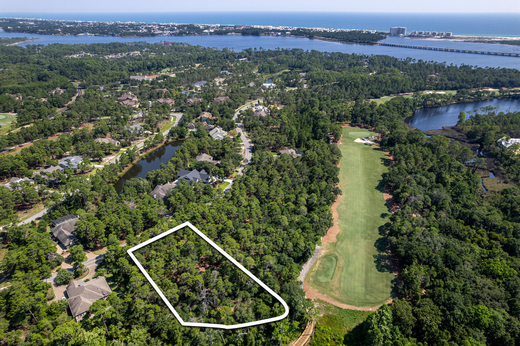 Nestled within the secure, gated community of Wild Heron, you'll discover this magnificent 1.14-acre wooded lot. It's a truly exceptional find, adjacent to the 12th tee of the renowned Shark's Tooth Golf Course, meticulously designed by Greg Norman and consistently recognized as one of Florida's top 5 golfing destinations. You have the flexibility to acquire this property on its own or explore the option of purchasing both lot 1613 and 1615, granting you the freedom to craft one or two homes - the potential is boundless! Without the constraints of a mandatory build-out timeline, these homesites cater to a wide range of preferences. Whether you're in search of a second home, a primary residence, or you're a builder looking to diversify your portfolio, these opportunities are versatile. Wild Heron, an exquisite neighborhood, upholds rental restrictions and graces the picturesque shores of Lake Powell, Florida's largest coastal dune lake. Here, you'll find a lifestyle of luxury, enriched by some of the most opulent amenities along the Emerald Coast.