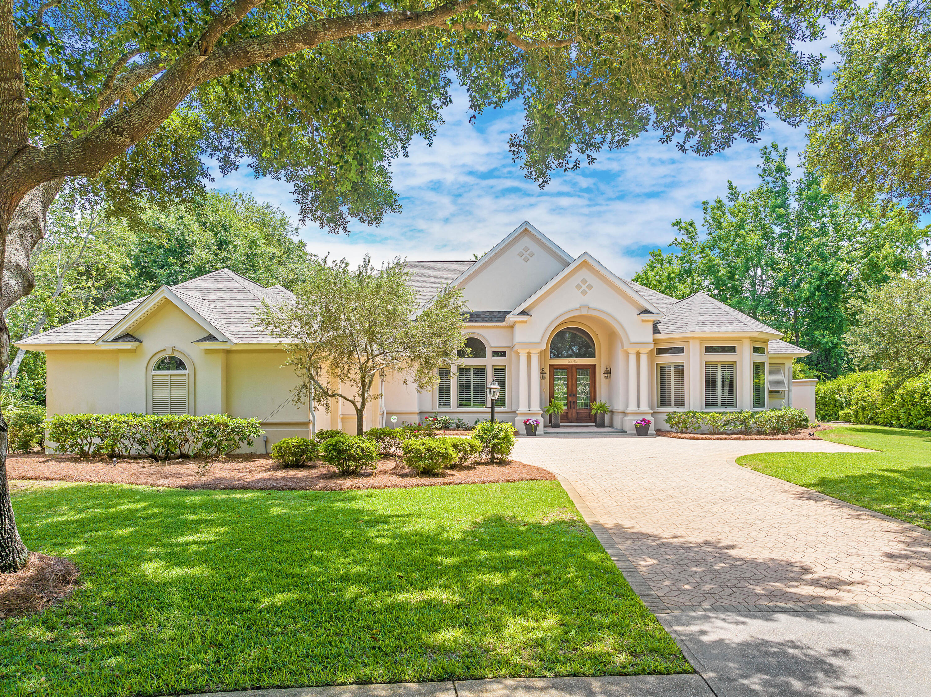 A NEW ROOF was just completed on this exquisite three bedroom home with an additional office in the prestigious Stonebridge neighborhood of Kelly Plantation, which sits on a sprawling .58-acre corner lot, offering privacy, charm and exceptional amenities. With its stately stucco exterior, shingle roof and dedicated golf cart garage, the property exudes sophistication while providing ample space to add a pool or a semi-circular driveway for added convenience. Designed for both relaxed living and elegant entertaining, the interior features warm and inviting family spaces alongside a grand formal living and dining area. The kitchen is well-appointed with a spacious island, raised breakfast bar and KitchenAid appliances, all complemented by a neutral color palette that allows for effortless customization. Multistage crown molding, ceiling treatments and a deluxe lighting package add to the home's refined character. A gas fireplace in the living room is a cozy complement in the cooler months of winter. A highlight of the property is the expansive 802-square-foot screened porch, which along with the interior spaces, have a wired sound system and are perfect for enjoying Florida's beautiful climate year-round. Additional features include tile flooring, plush carpeted bedrooms, a paver patio and a central vacuum system. Additionally, this home faces a large park in the center of an oversized round-a-bout, so the front yard view and curb appeal is impeccable. Located within the gates of Kelly Plantation, residents enjoy championship golf, tennis, pickleball, a community pool, miles of walking trails and a private dock for paddleboarding and kayaking. The owners' clubhouse was recently remodeled, and this furnished space with outdoor grills is available for owners to reserve for private parties. Next door you will also find a fitness room and a separate yoga/pilates studio. Sports courts and 24-hour security complete this unparalleled lifestyle, with the beach, Whole Foods, Fresh Market and Destin Commons just a short golf cart ride away. Meticulously maintained by its current owners, this home offers an extraordinary opportunity to experience luxury living in one of Destin's most sought-after communities.