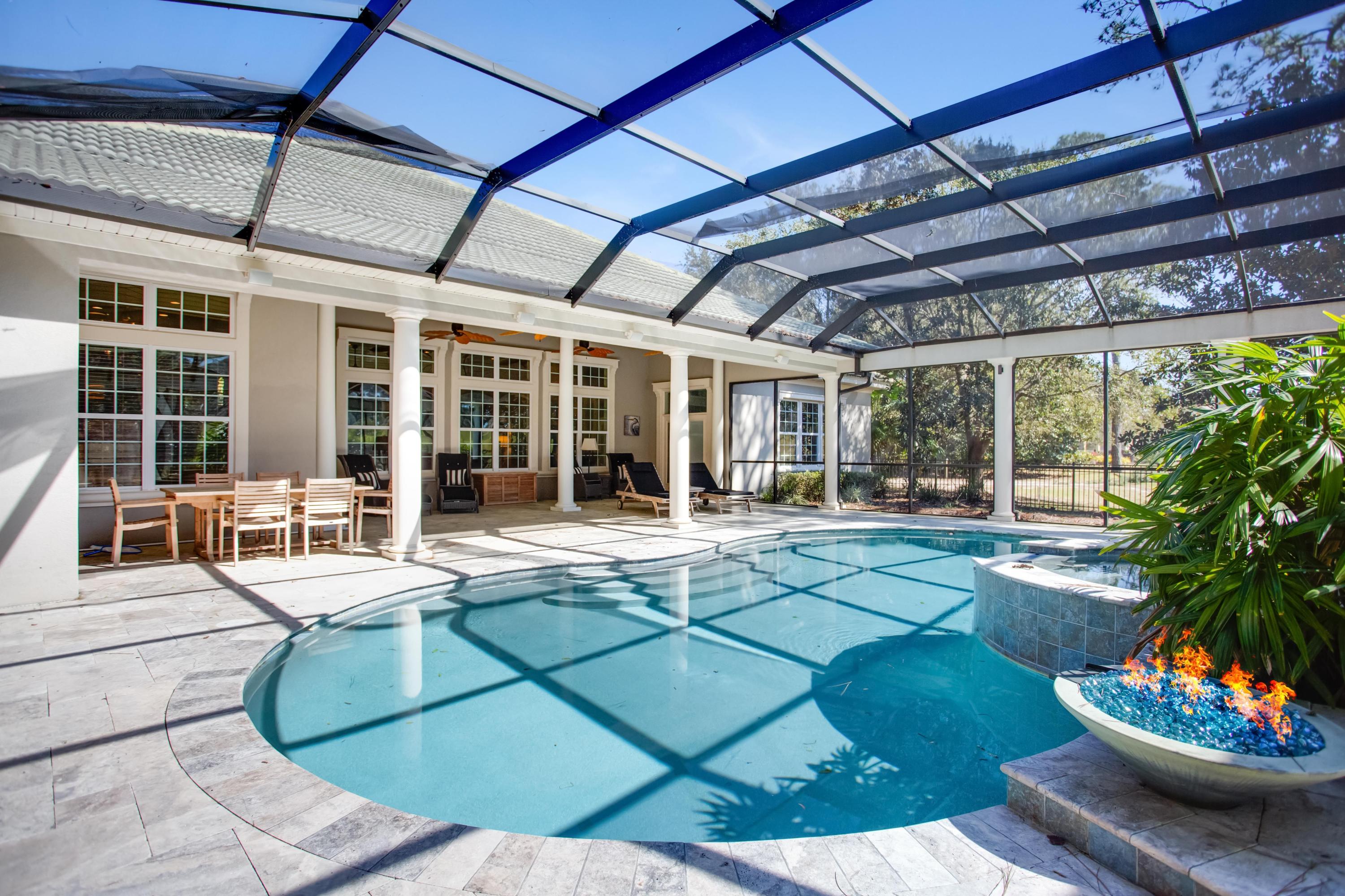 This breathtaking Mediterranean estate situated alongside the 2nd green of the Burnt Pine Golf Course offers the best in luxury living blended with private retreat. Stately columns accented by gracious arches and solid mahogany double doors greet you upon arrival. From the moment you enter this home, you are overtaken by the 14 foot coffered ceilings and expansive open spaces. Designed for entertaining, the open-concept floorplan features a formal dining room that could easily accommodate large sit-down gatherings, an adjacent wet bar with built in wine refrigerator and ice maker, and a magnificent open great room. The great room boasts a wall of windows designed to maximize natural light and spectacular views as well as custom built-ins and ample space for a grand-