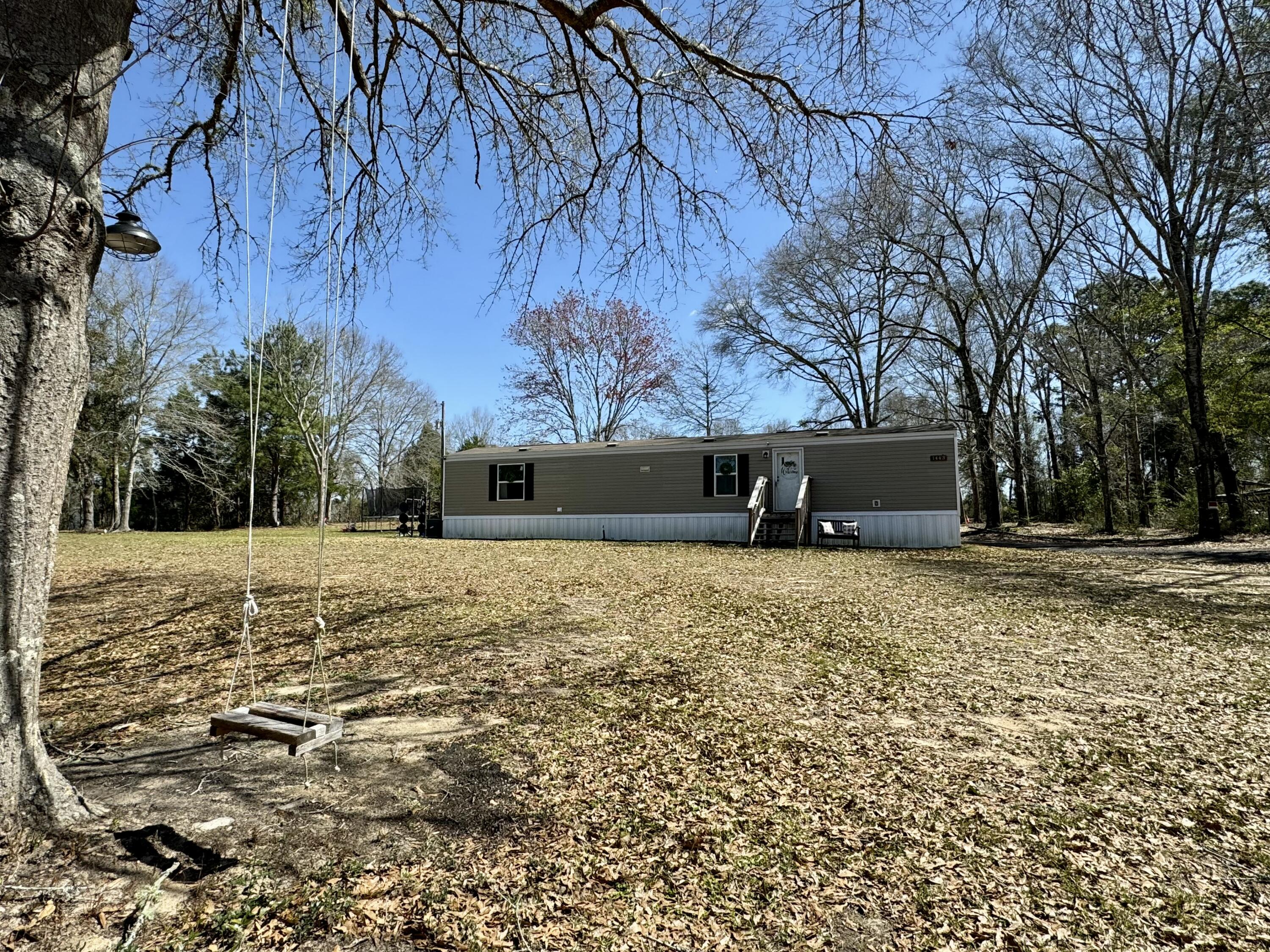 Discover tranquility on this one-acre lot in Baker, FL. This 2021-built, 2-bedroom, 2-bathroom home offers peaceful country living. Located north of the 189 and Hwy 4 intersection, at the end of Dan Barnes Road, you'll enjoy the quiet surroundings. The seller will leave the washer and dryer, the chicken coop may convey at the buyer's request.