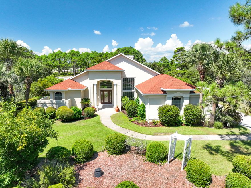 Size, location, natural light, and outdoor space define this inviting home in Santa Rosa Beach. Situated on one-half acre, this charming home has had one owner and has been well cared for over the years.  The property abuts the 8th hole of the Santa Rosa Golf and Beach Club.Notable features include an oversized two-car garage, vaulted ceilings, and tastefully landscaped front and back yards full of mature trees. From the screened and covered back porch, you can relax while watching golfers take birdie putts.Inside, the vaulted ceilings create an open, airy feel. The entry opens to a formal living room with a large window overlooking the porch. To the left, the primary suite includes French doors to the porch, two walk-in closets, and a spacious bathroom with double vanities, a jetted garden tub, and a large walk-in shower.

The home also offers a formal dining room, two additional bedrooms with a shared full bathroom, and a generous laundry room with direct access to the garage which features built-in cabinetry. Toward the back of the home, the family room and kitchen form a comfortable gathering space. The kitchen includes granite countertops, stainless steel appliances, and plenty of cabinet storage, while the family room features a propane fireplaceperfect for cool winter evenings on the Emerald Coast.
A fourth bedroom, most recently used as an office, rounds out the floor plan and provides flexibility for your needs.
Being located on the south side of Highway 98, access to 30A is a piece of cake! Easily take your bikes or golf cart down to Gulfplace, Shunk Gulley, The Perfect Pig, Pecan Jacks, and Ed Walline public beach access, just to name a few of the hot spots. 