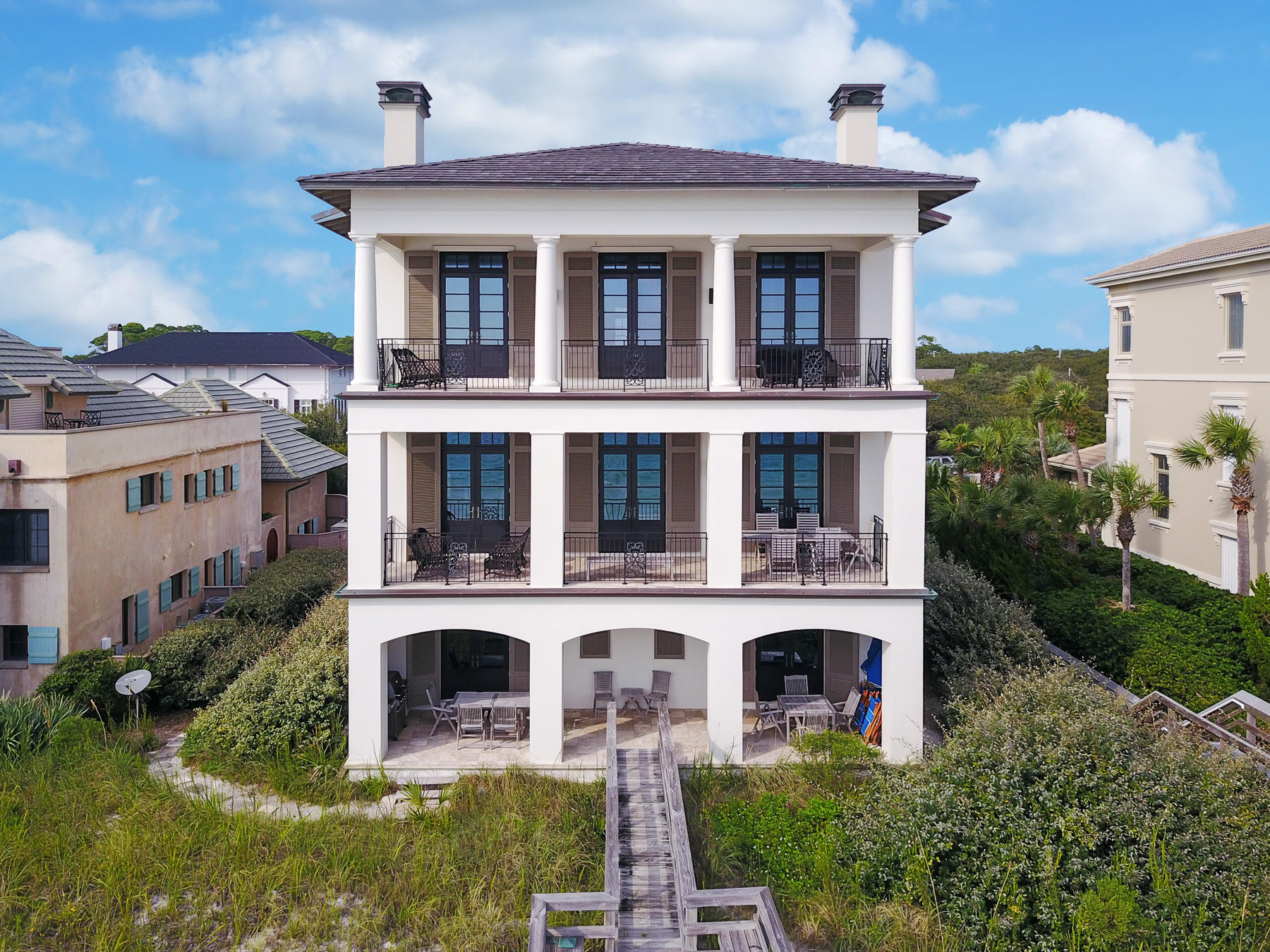 Simple sophistication meets seaside style in this Gulf front 6,500 square foot concrete constructed home. The interior elegance of this villa gives an old world, European aesthetic with a touch of modern refinement with finishes like hardwood and travertine tile flooring, 12-foot raised ceilings with exposed wood beams, hand wrought chandeliers, custom crafted wood cabinetry, matching masonry fireplaces with cast stone mantles and French doors. Although, the design throughout this home is simply divine, the real showstopper is the incredible Gulf front views and private beach access that is directly off of your back porch.