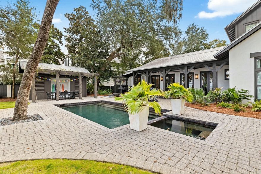 Discover unparalleled waterfront living in this stunning Bay Front estate with 100 feet of private water frontage on the Choctawhatchee Bay, located in the exclusive gated community of The Estuary. Designed by Tammy Massey and built by Arkon, this concrete-built home showcases timeless elegance with breathtaking bay views, a private pool and pool house, and a covered boat slip with a dock.This exquisite property features 5 bedrooms, including a main-level master suite with vaulted ceilings, floor-to-ceiling windows, and expansive views of the bay. The master bath boasts an oversized dual vanity, frameless shower, soaking tub, and a spacious walk-in closet with custom built-ins. The second level offers two large bedrooms, each with en-suite baths and stunning north-facing views of the