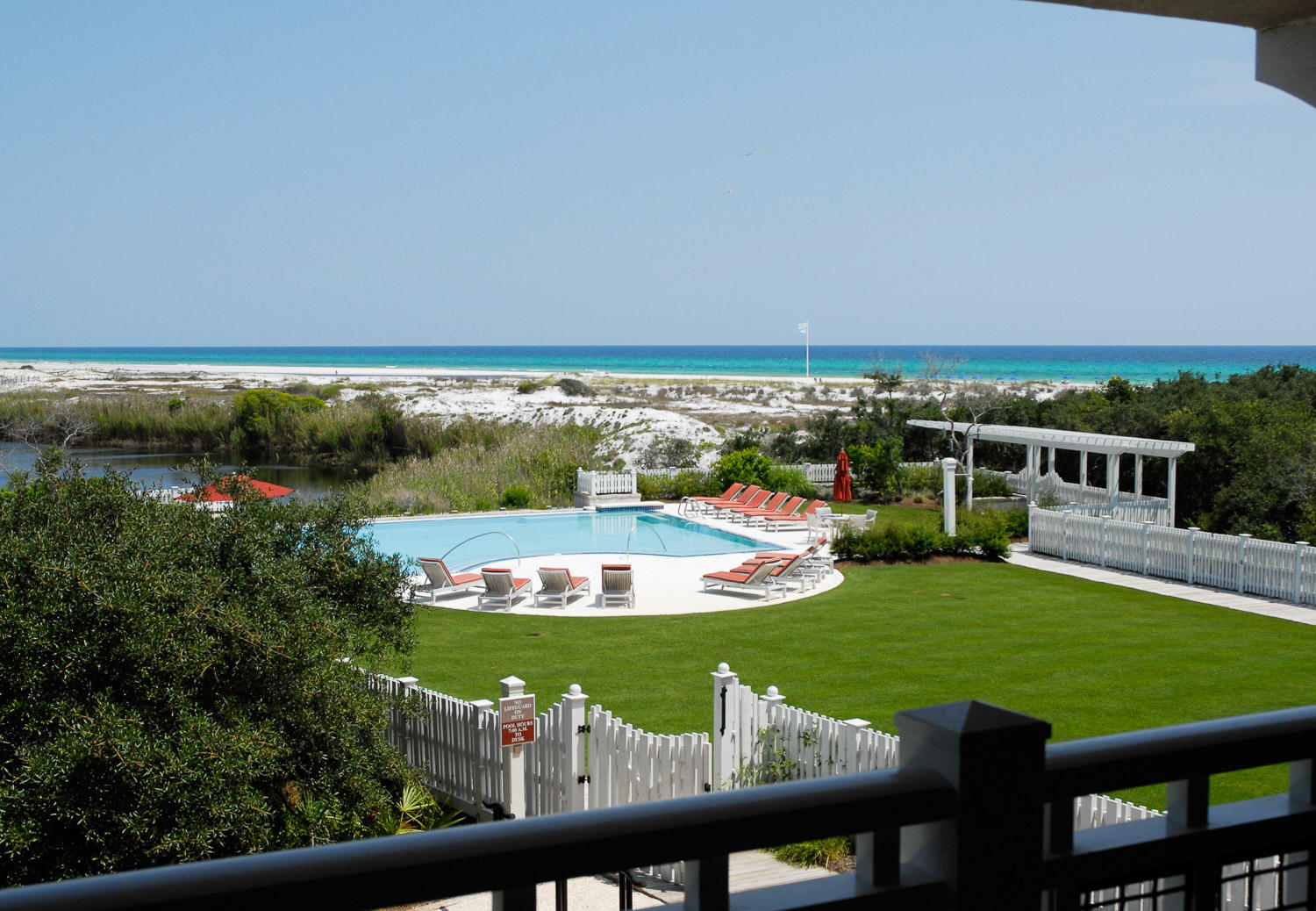 Just steps to the Beach, this 3-bedroom, 3.5 bathroom townhouse style condo features gulf, lake and pool views! Inside you will find gorgeous hardwood floors in the kitchen, dining and living areas. Gourmet kitchen, with granite countertops, stainless steel appliances, and a Viking gas range. Master bedroom is located on the first floor with private bathroom with a shower and a spa tub, and a private screened porch. Two guest rooms are located on the second floor both with ensuites. The second-floor balcony offers outstanding views and a great place to relax and enjoy. You will find plenty of room for storage in the attached garage! Enjoy the private and beautiful community pool nearby or take a quick walk over to the beach and enjoy the GULF.