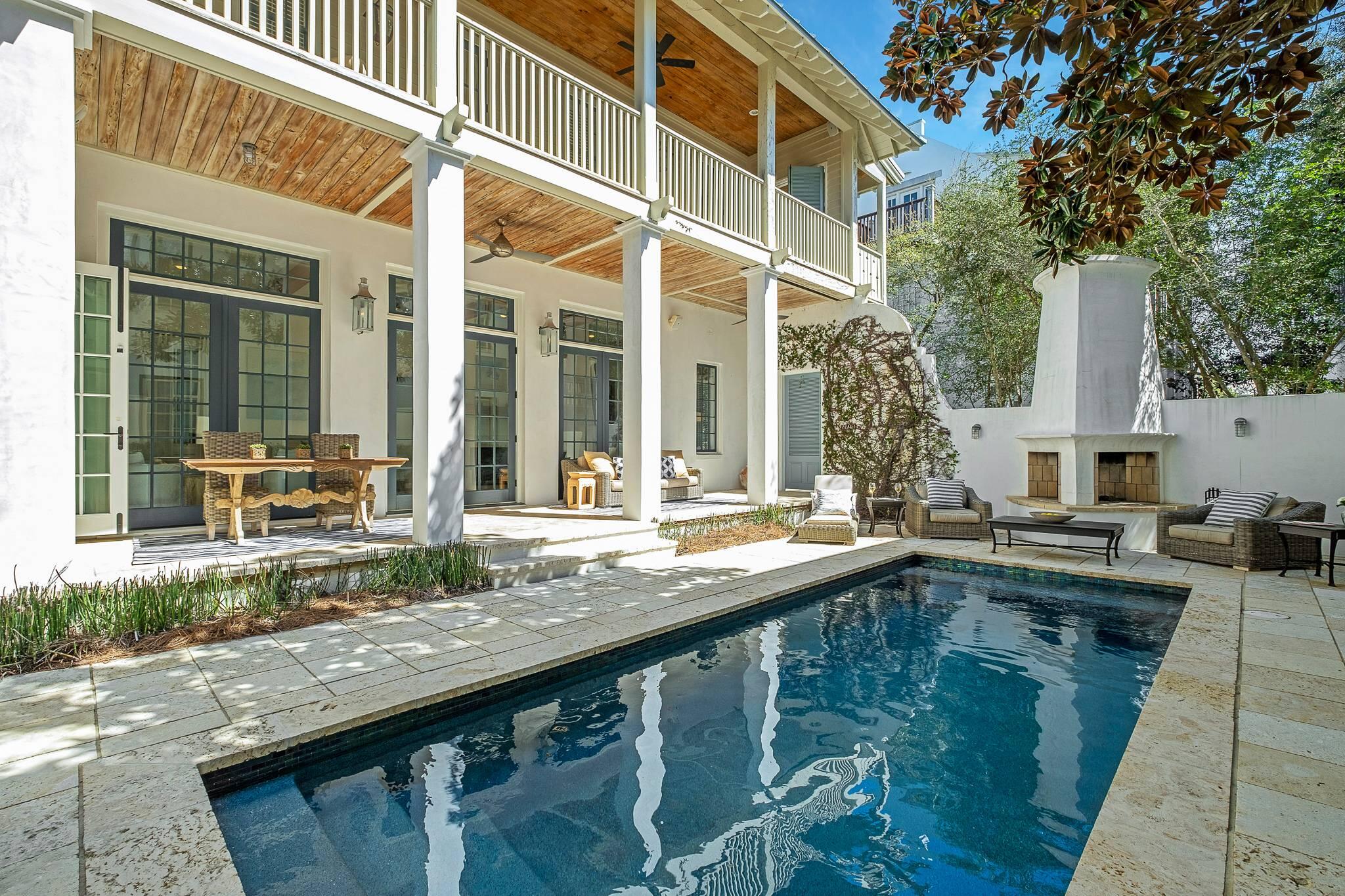 Step into one of Rosemary's largest outdoor yard living spaces, a serene sanctuary. Located on the coveted side of 30a with easy beach access. This Rosemary Beach home with a pool and carriage house is designed to entertain. The living, dining and outdoor porch includes two fireplaces and eating areas  that flow as one gracious space. Soft palettes of blues, greens, and sand colored decor by Pizitz of Seaside. Craftsmanship abounds with old Florida pecky cypress beams and 100 year sinker cypress custom cabinets, as well as all new white oak beach washed flooring. The home has been completely remodeled and features beautifully tiled bathrooms and new cabinetry. Start with a perfect kitchen inside where the meal completes with outdoor grilling under the vine covered pergola.