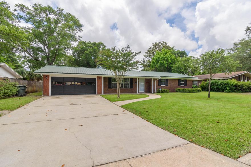 This charming Ranch style home offers many wonderful updates throughout, with two living spaces and a wonderful screen enclosed patio (16x17). Enjoy the amenities of the neighborhood such as sidewalks, neighborhood park, pickleball, and tennis courts in walking distance. The kitchen comes equipped with granite counter tops, breakfast bar, pantry, wall oven, built-in microwave, fridge with ice and water dispenser, electric cooktop, abundant cabinet storage, skylight and finished nicely with a natural stone tile backsplash and Travertine flooring. Just off the kitchen is a cozy den with a wood burning fireplace with French doors that open to the screened patio. You'll also enjoy the formal dining room and living room suitable to entertain the whole family. Both bathrooms have been completely renovated with gorgeous Travertine tile. The primary bathroom has a large vanity with additional storage and a shower tub combo with glass doors and a skylight. The additional bathroom has a walk-in shower with glass doors and additional storage and both bathrooms have water saving eco friendly flushing toilets. Other notables are new windows, METAL ROOF, USB ports in kitchen and den, termite bond, fully fenced back yard, 2 side doors into garage, large laundry room with additional storage, climate controlled garage, sprinkler system, gutters, all brick exterior, security system, crown molding, recessed lighting, granite window sills and 2 pocket doors closing off the kitchen and den making for the perfect late night quiet retreat for adults. Just 5 miles to Okaloosa Island and the beach, 6 miles to the airport, 1.3 miles to Fort Walton Beach Golf Course and 5 miles to Eglin and Hurlburt AFB. Walk to Elementary School. New entertainment development Freedom Beacon Park coming soon. What a location! Check out our full video tour on the MLS and YouTube.